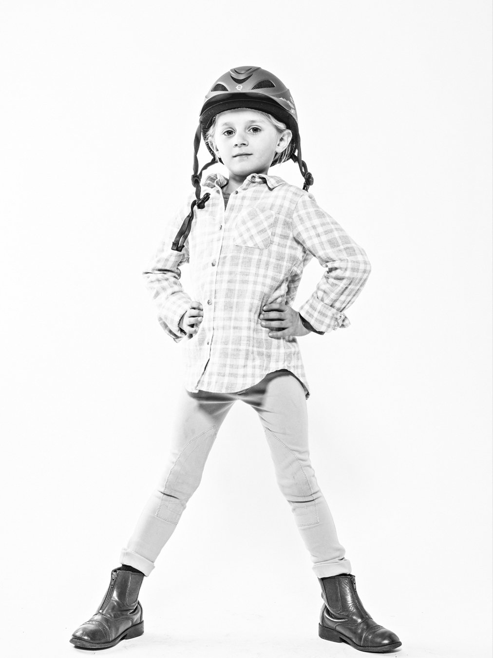 little girl in her horseback riding helmet. black and white image on white background. portsmouth NH