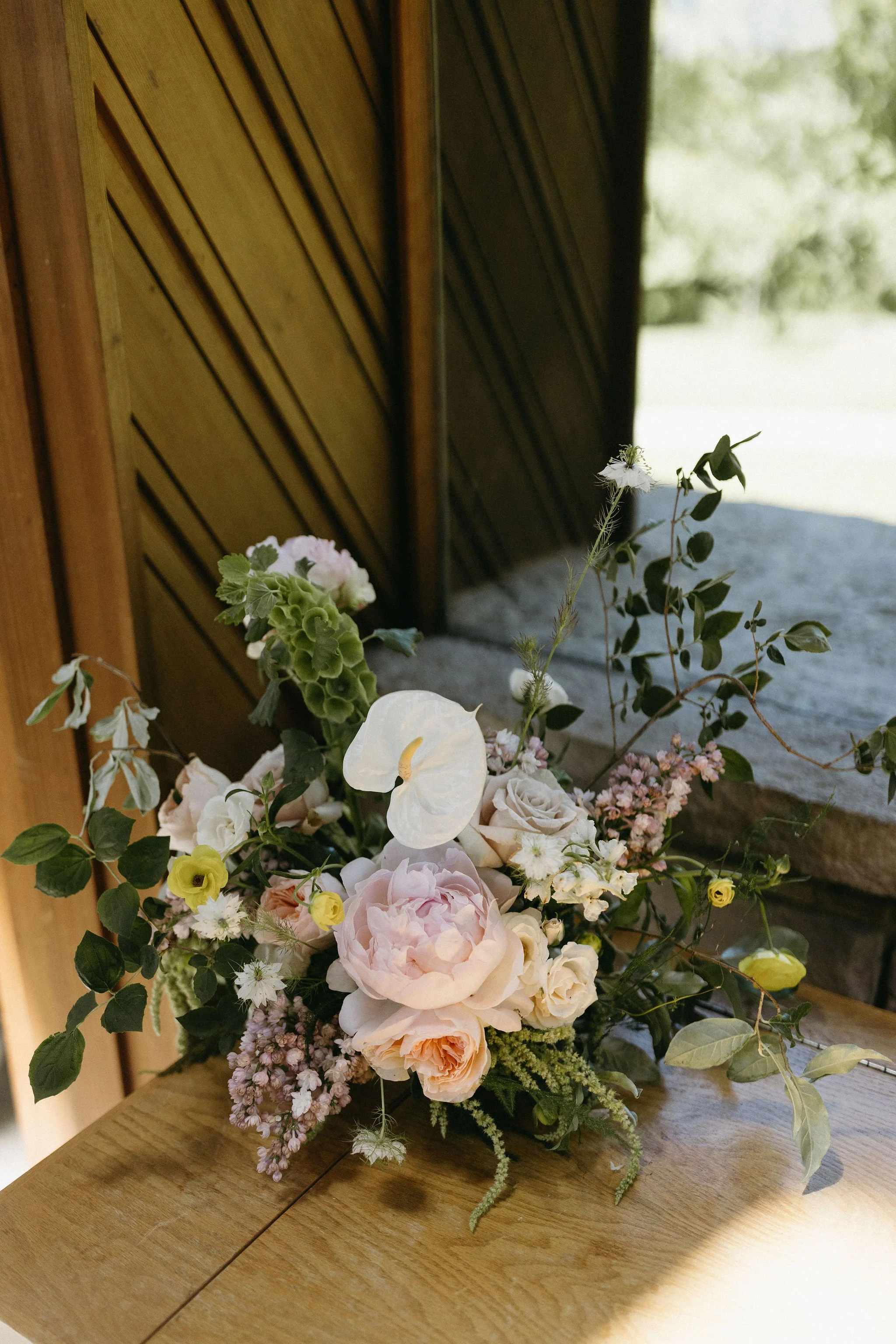 modern spring garden wedding warm color palette yellow peach lilac the cottage rose kansas city florist crossroads powell garden ceremony welcome arrangement peonies anthurium garden roses ranunculus