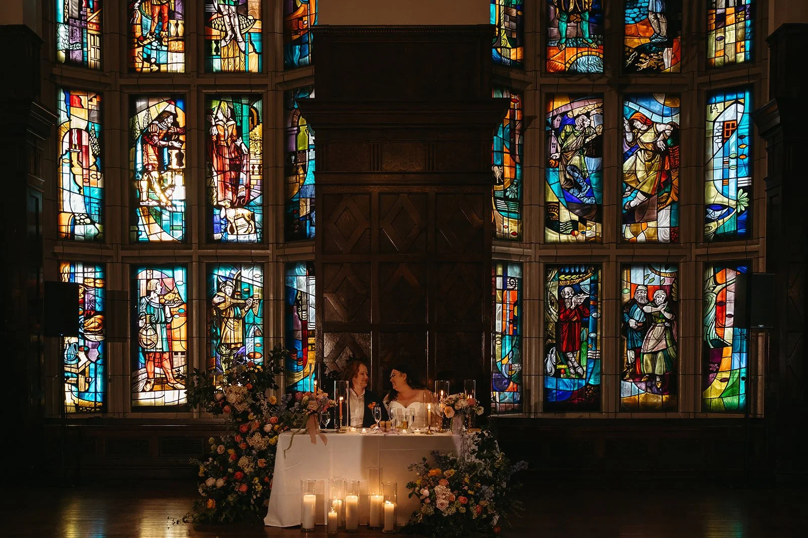 candlelit whimiscal spring garden wedding pastel color palette same sex wedding reception sweetheart table floral installation aisle flowers downtown kc hotel kansas city the cottage rose kansas city wedding florist crossroads
