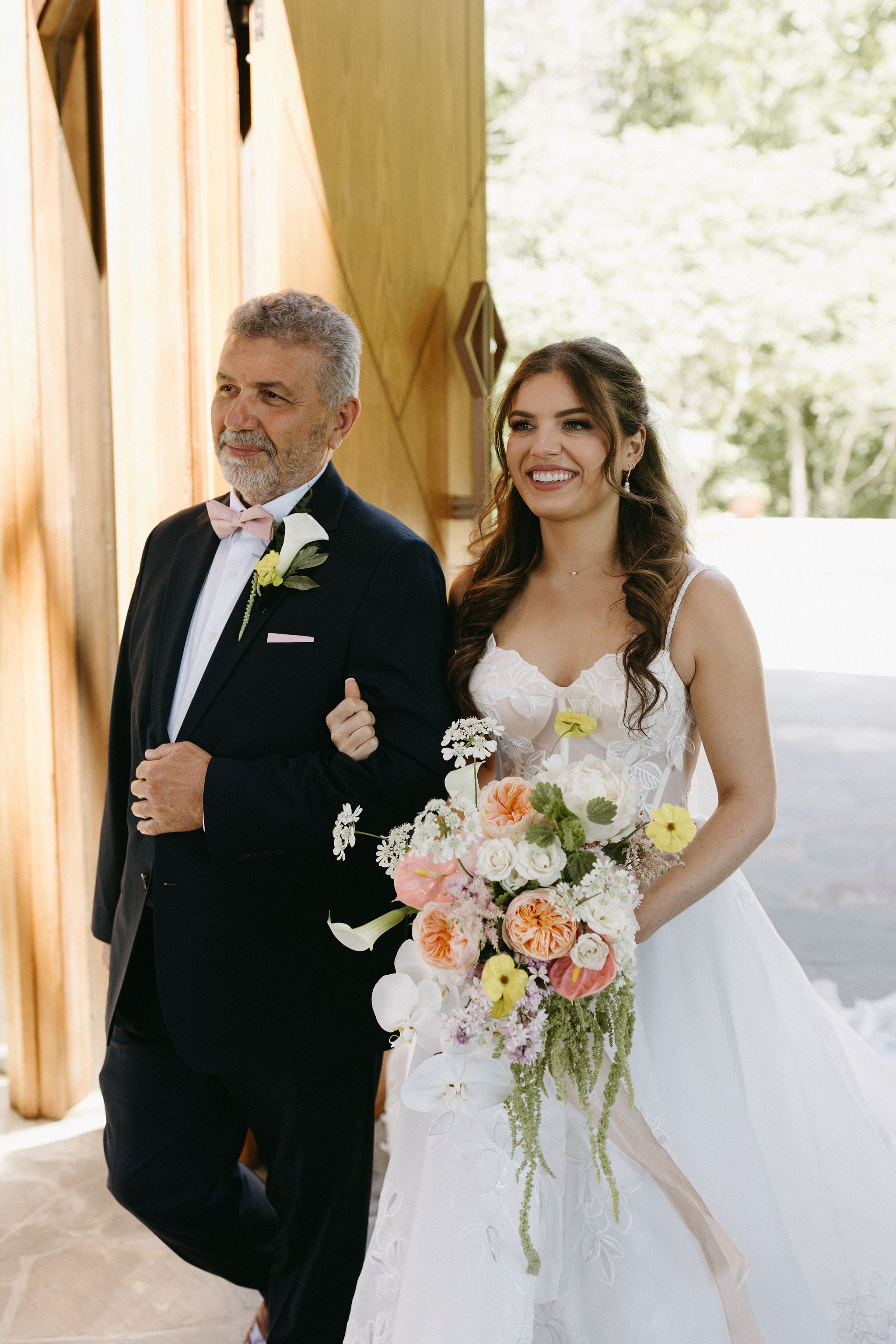 modern spring garden wedding warm color palette yellow peach lilac the cottage rose kansas city florist crossroads powell garden ceremony father and bride in ballgown large statement bouquet yelllow peach lilac