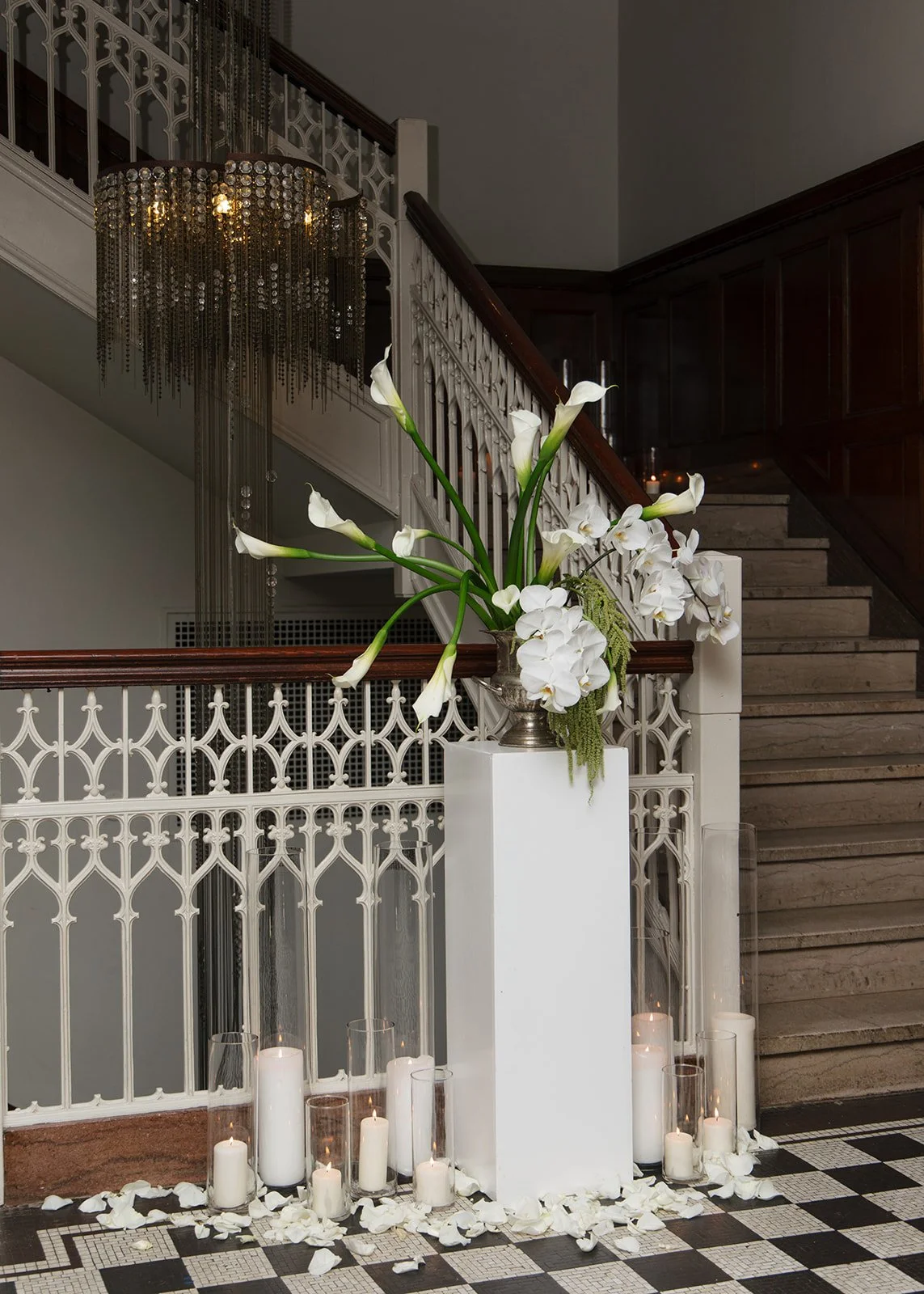 Modern chic november fall wedding downtown hotel kansas city rose petals orchids calla lilies amaranth wedding ceremony arrangement pedestal candles staircase focal point installation the cottage rose kansas city wedding florist crossroads