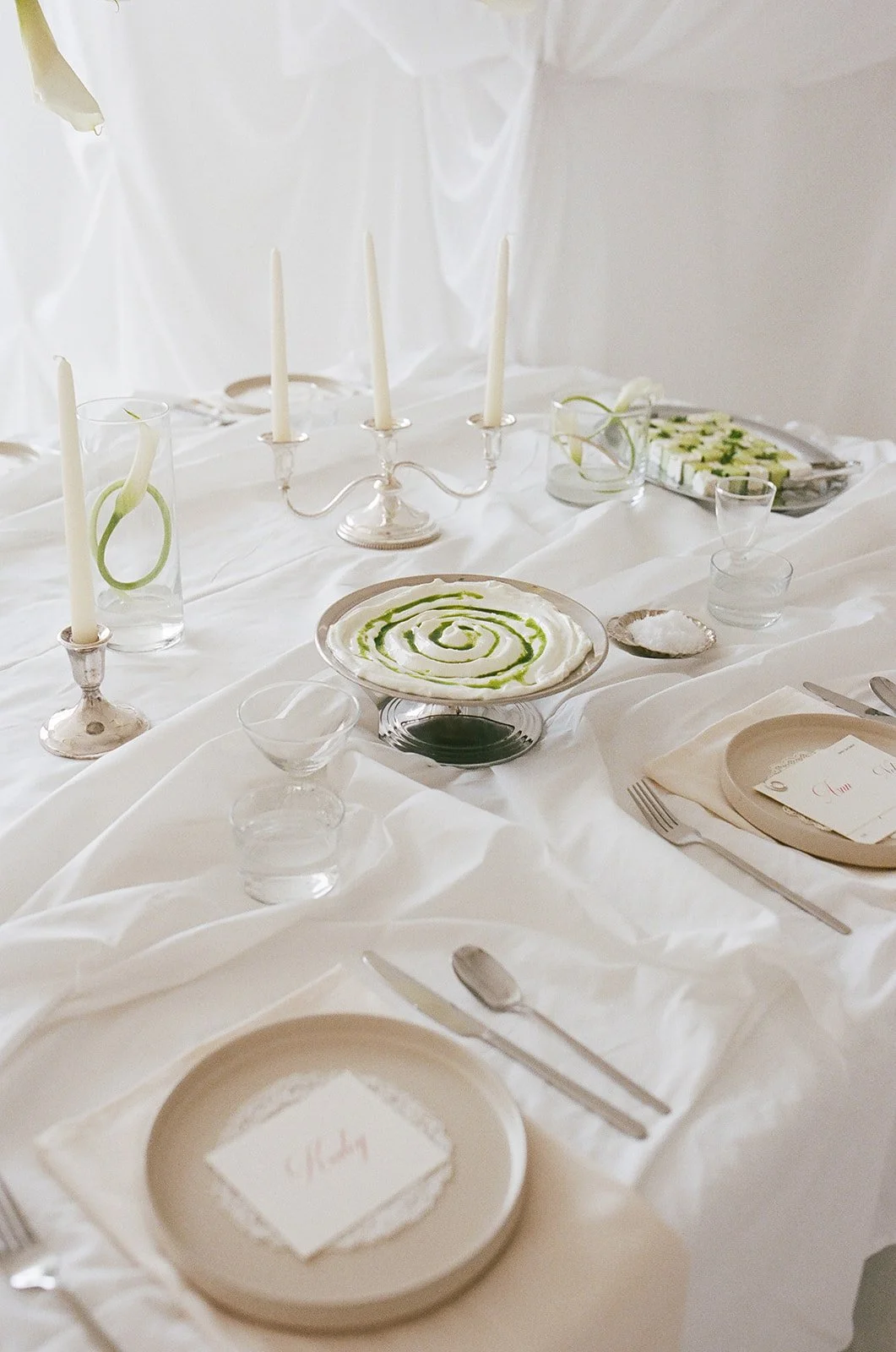 Chic Modern Baby Shower in a Cloud with layers of white draped fabric, simple calla lily centerpieces,  silver candlesticks, hanging floral installation the cottage rose kansas city florist crossroads white set silver food platters
