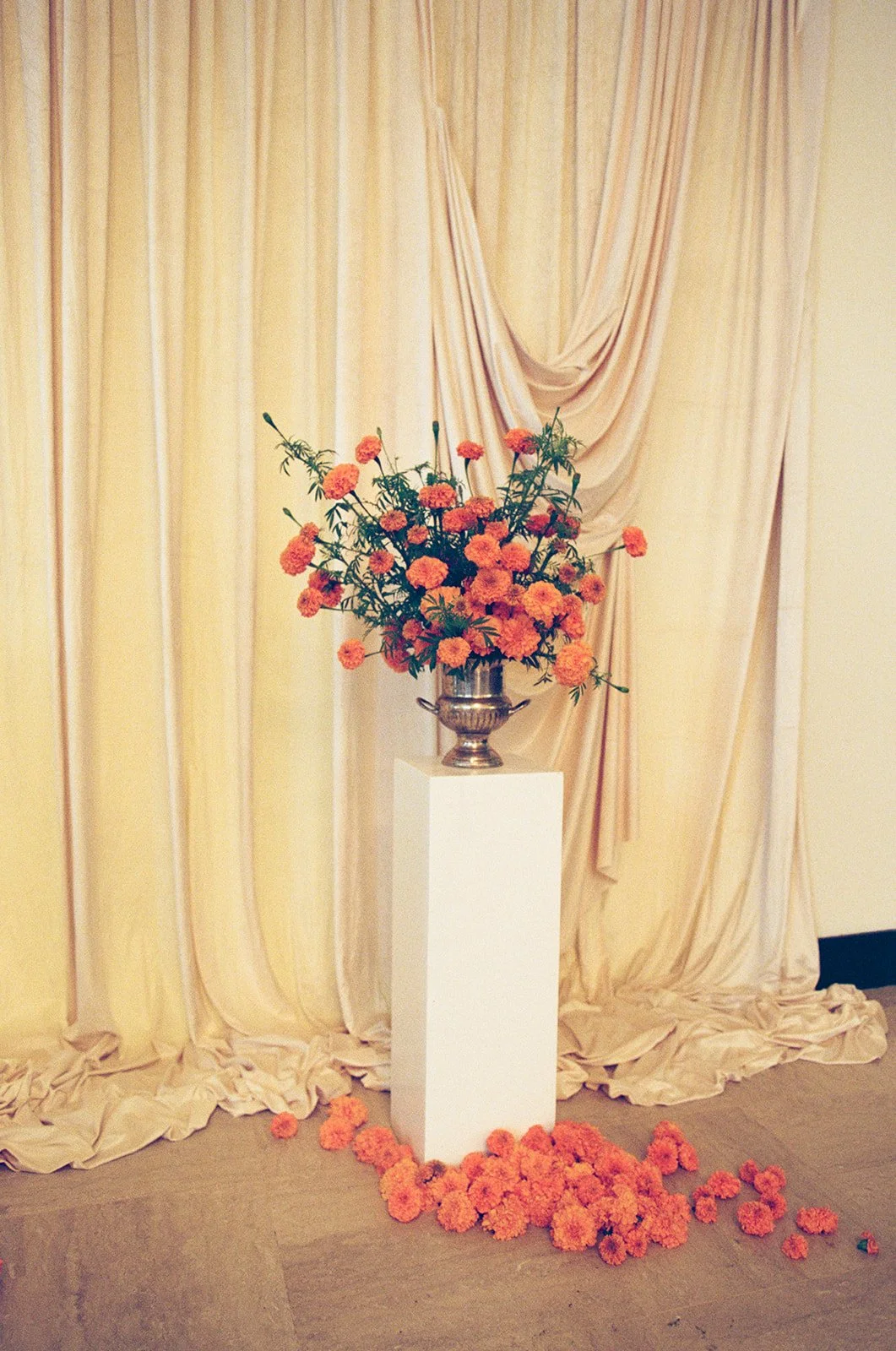 Modern september wedding ceremony ivory draped fabric orange and yellow color palette floral pedestals marigolds library wedding ceremony altar arrangements the cottage rose kansas city wedding florist crossroads hotel kansas city wedding