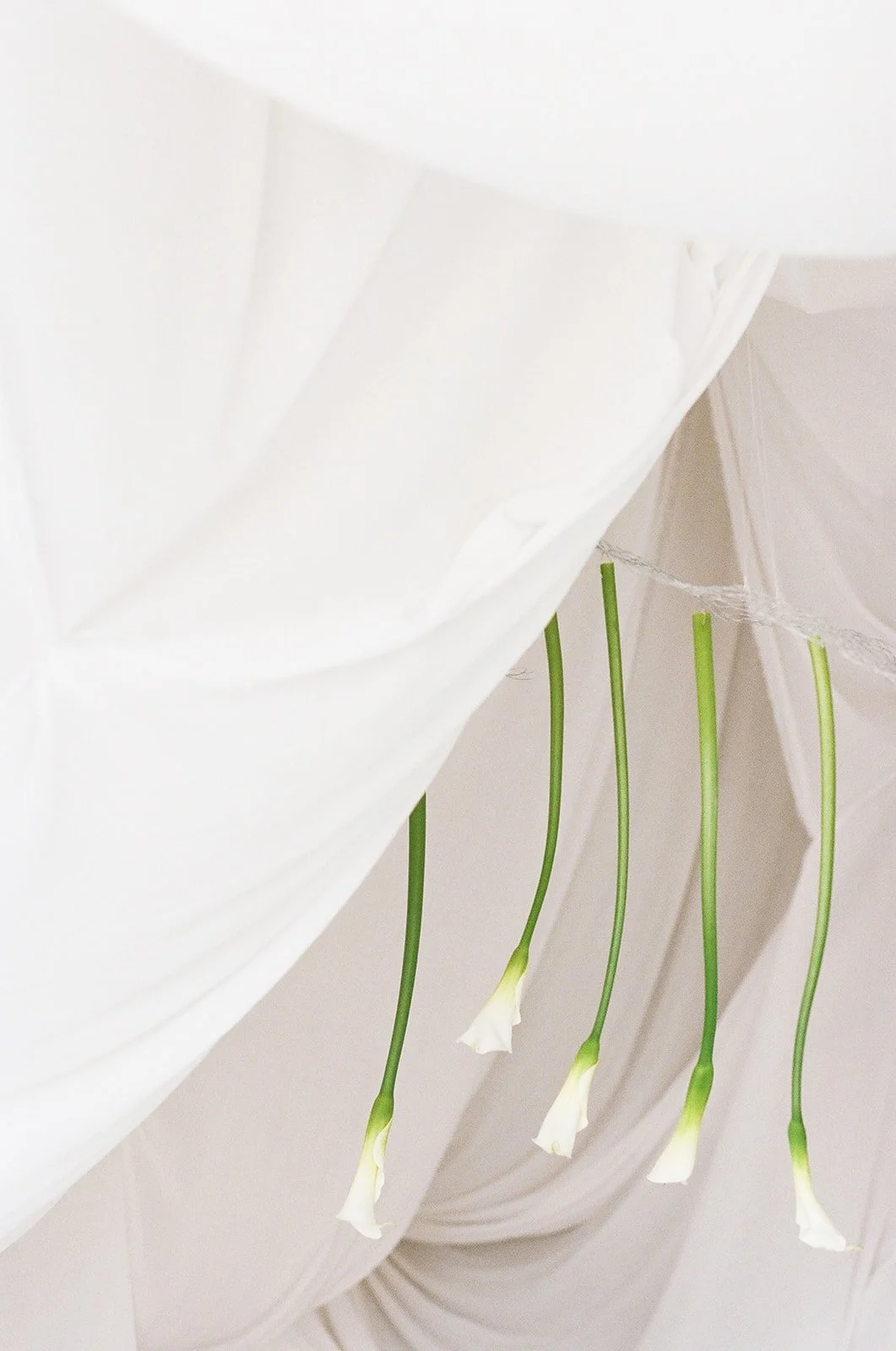 Chic Modern Baby Shower in a Cloud with layers of white draped fabric, simple calla lily centerpieces,  silver candlesticks, hanging floral installation the cottage rose kansas city florist crossroads