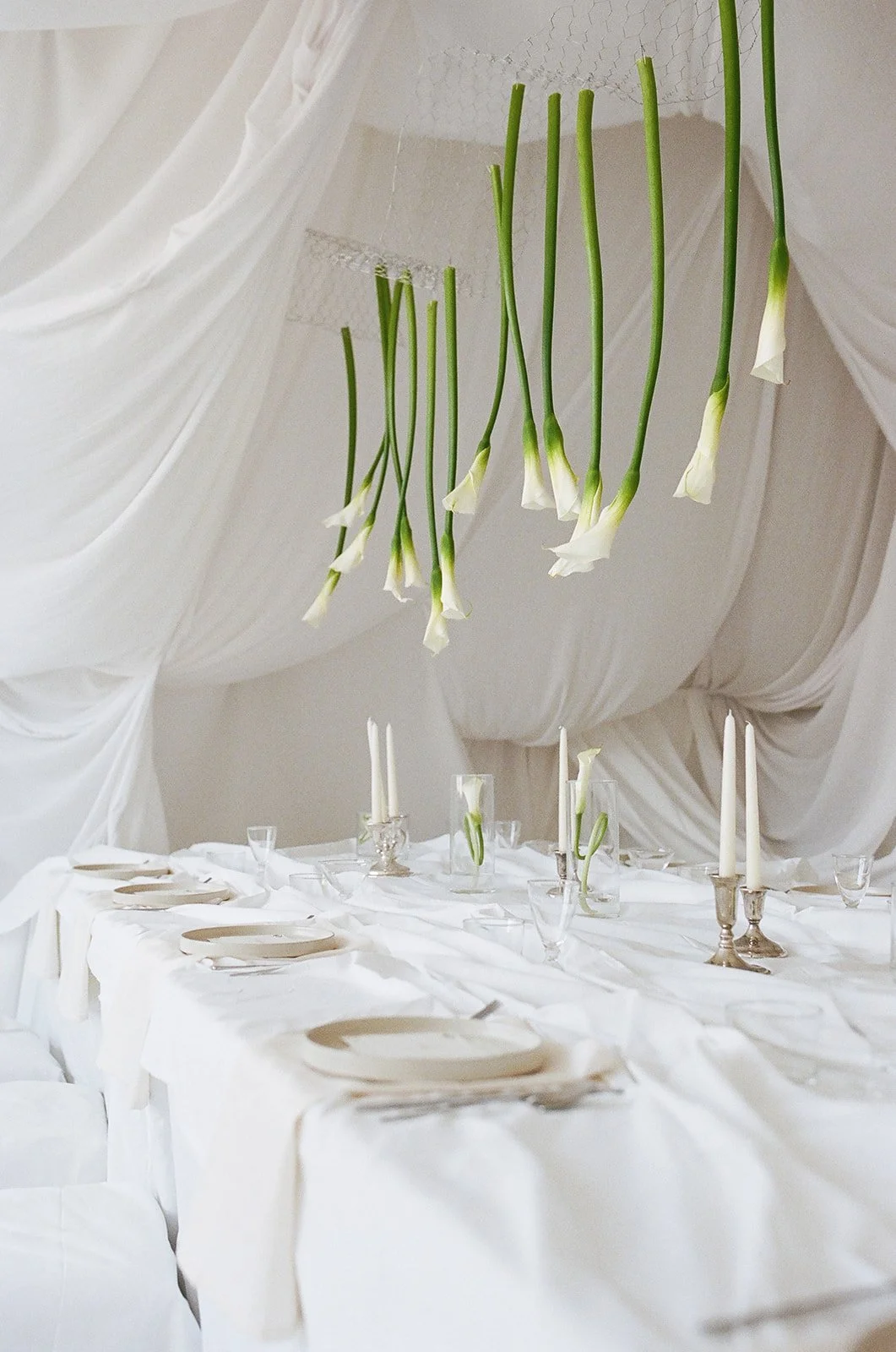 Chic Modern Baby Shower in a Cloud with layers of white draped fabric, simple calla lily centerpieces,  silver candlesticks, hanging floral installation the cottage rose kansas city florist crossroads