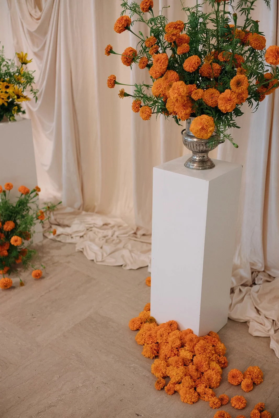 Modern september wedding ceremony ivory draped fabric orange and yellow color palette floral pedestals marigolds library wedding ceremony altar arrangements the cottage rose kansas city wedding florist crossroads hotel kansas city wedding