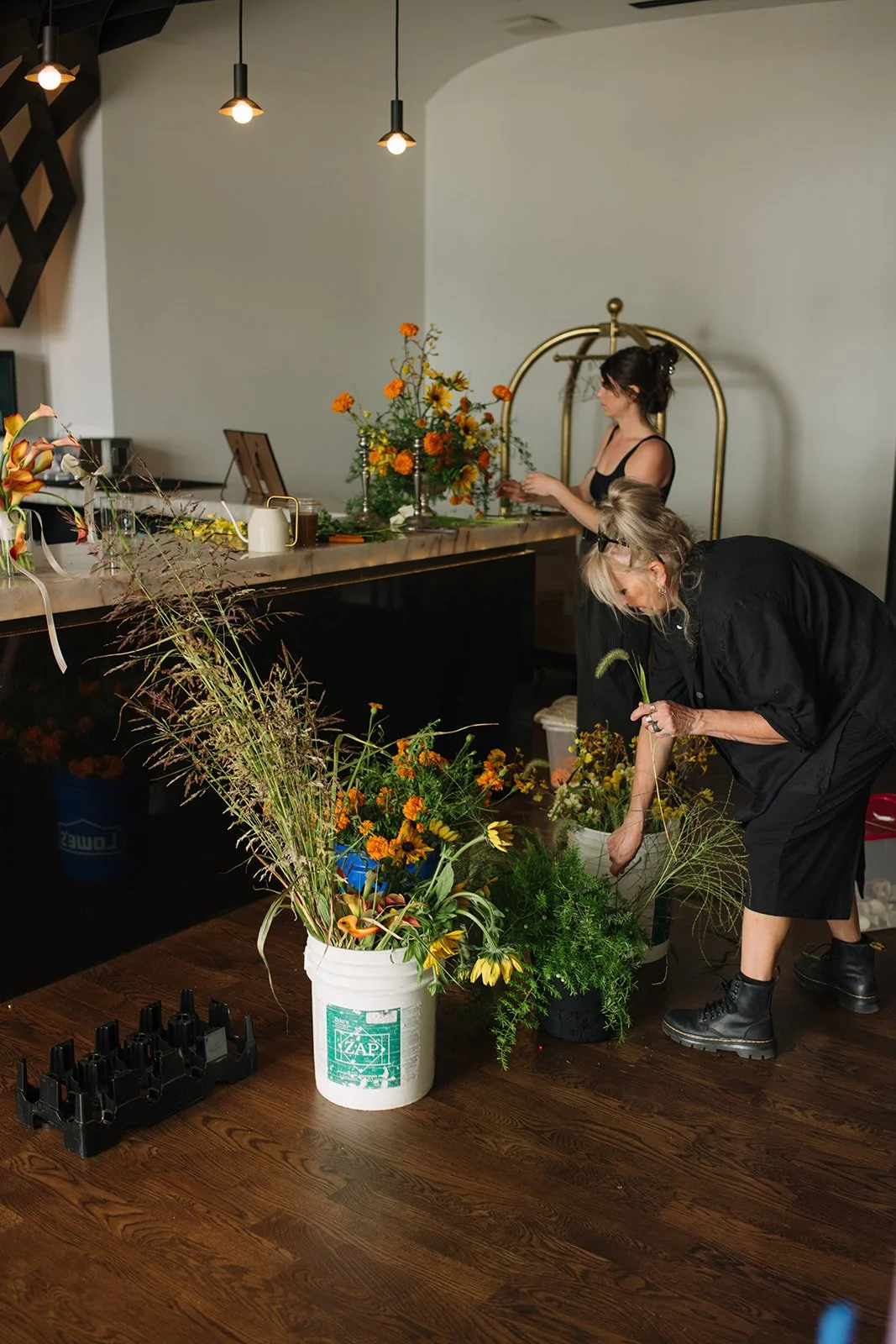 Modern september wedding orange and yellow color palette seasonal flowers calla lilies marigolds bar arrangement wedding bridal portraits the cottage rose kansas city wedding florist crossroads hotel kansas city wedding