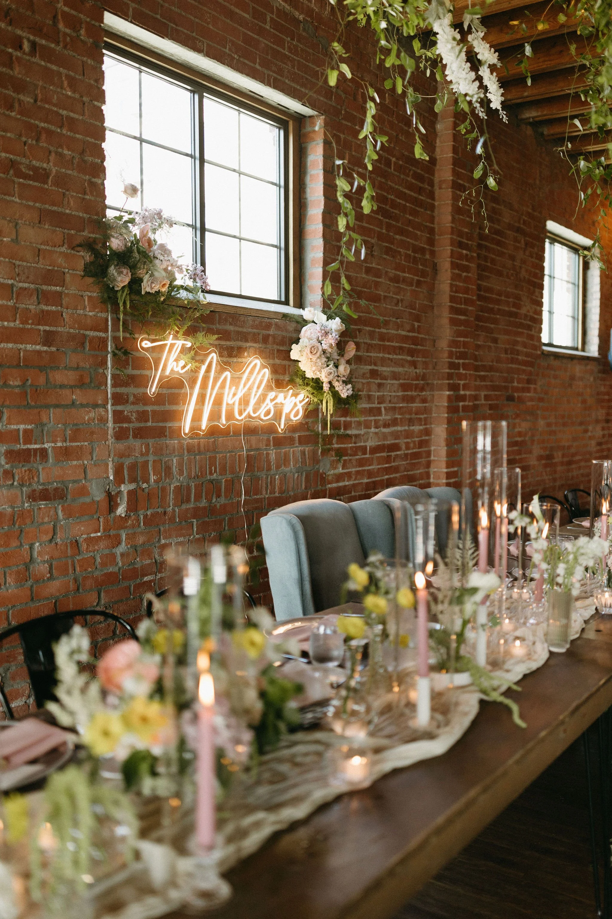 modern spring garden wedding warm color palette yellow peach green the cottage rose kansas city florist crossroads powell garden reception hanging greenery bud vases taper candles ikebana flower arrangements centerpieces head table decor