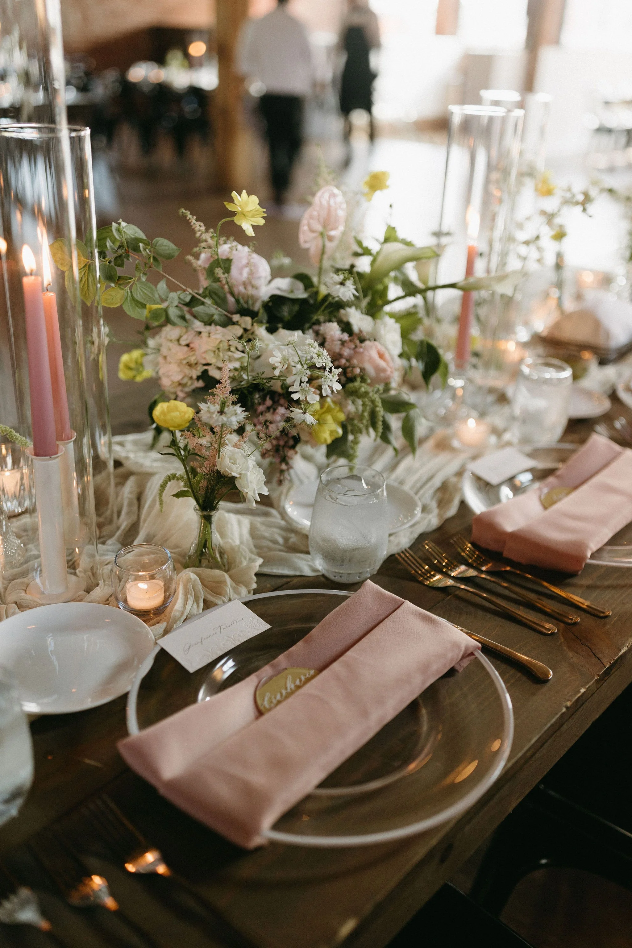 modern spring garden wedding warm color palette yellow peach green the cottage rose kansas city florist crossroads powell garden reception hanging greenery bud vases taper candles ikebana flower arrangements centerpieces head table decor