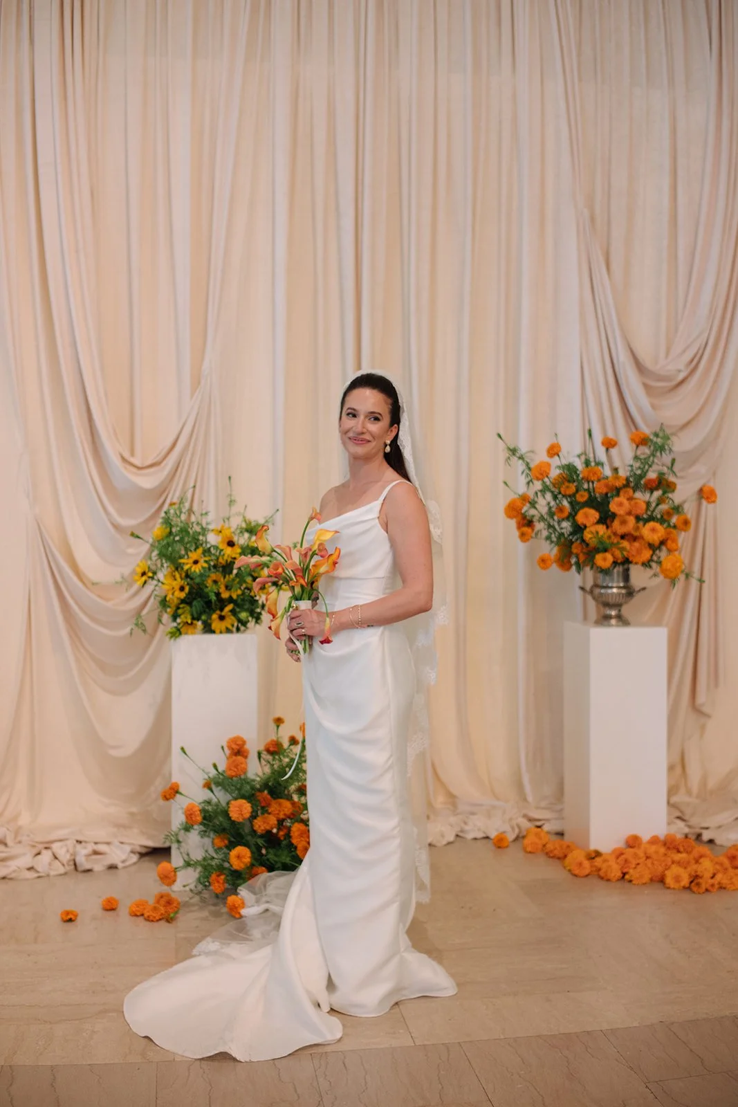 Modern september wedding ceremony ivory draped fabric orange and yellow color palette floral pedestals marigolds library wedding ceremony bridal portraits the cottage rose kansas city wedding florist crossroads hotel kansas city wedding