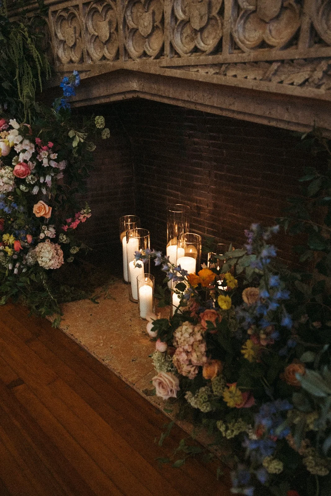 candlelit whimiscal spring garden wedding pastel color palette same sex wedding ceremony fireplace floral installation aisle flowers downtown kc hotel kansas city the cottage rose kansas city wedding florist crossroads