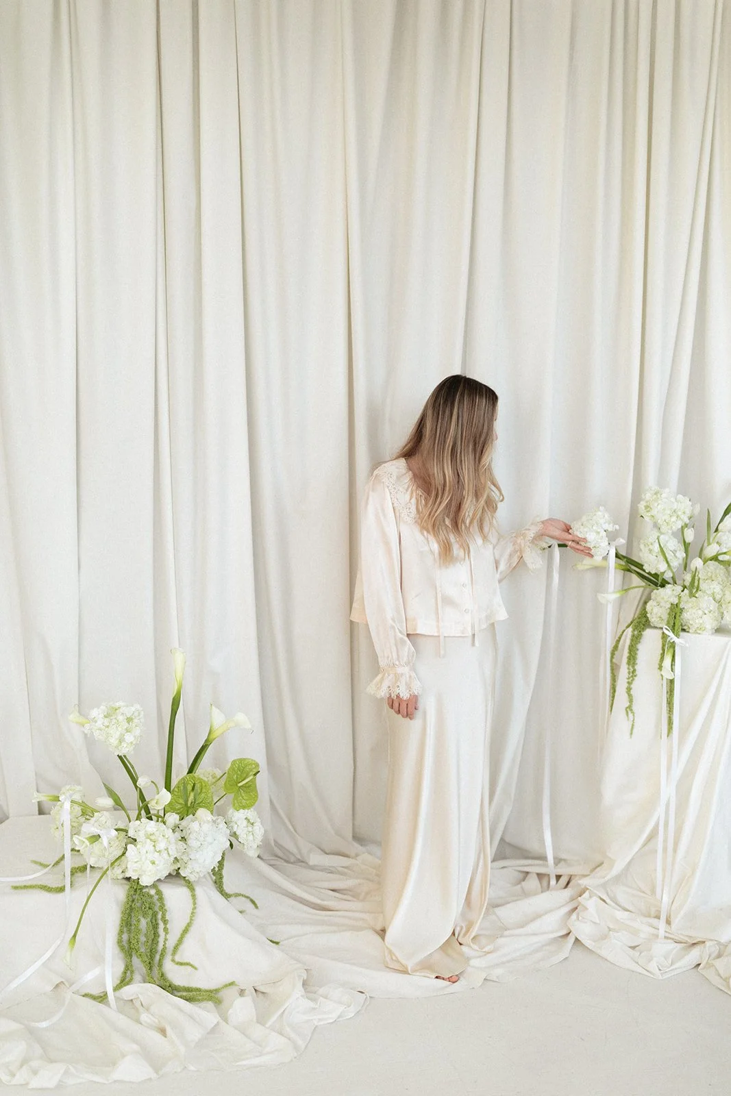 Modern chic branding shoot for an interior designer white and green flowers amaranth calla lilies anthurium hydrangea the cottage rose kansas city wedding florist crossroads pedestal floral installation draped fabric model in ivory silk set