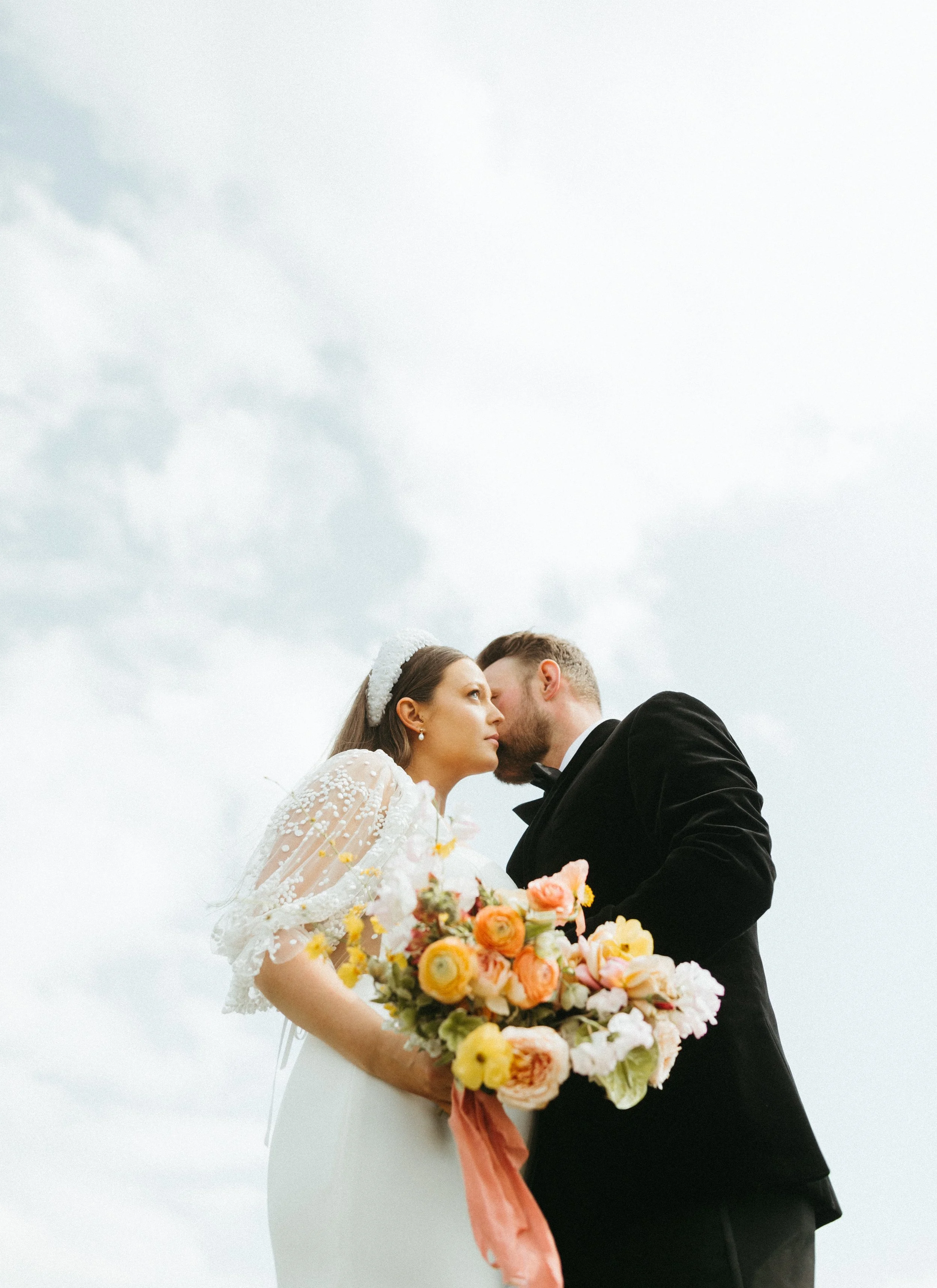 Bride and groom portrait nelson atkins sky backdrop large lush spring bridal bouquet modern bridal style the grand hall downtown kc the cottage rose kansas city wedding florist crossroads nelson atkins museum