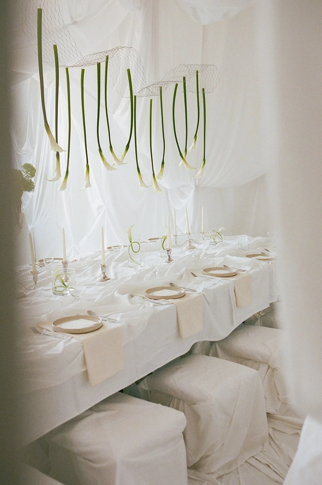 Chic Modern Baby Shower in a Cloud with layers of white draped fabric, simple calla lily centerpieces,  silver candlesticks, hanging floral installation the cottage rose kansas city florist crossroads