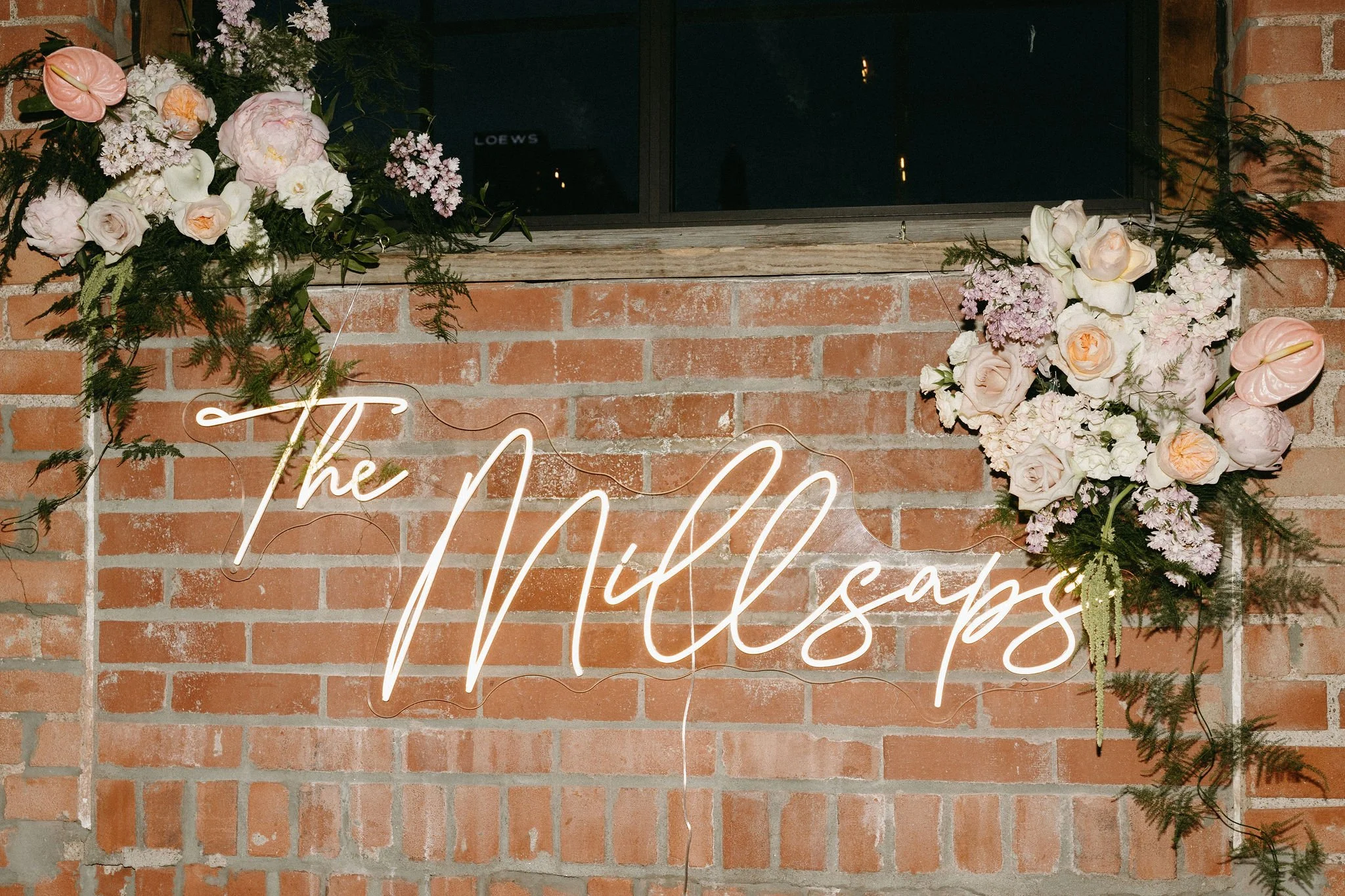 modern spring garden wedding warm color palette yellow peach green the cottage rose kansas city florist crossroads powell garden reception hanging greenery bud vases taper candles ikebana hanging wall florals head table decor neon sign