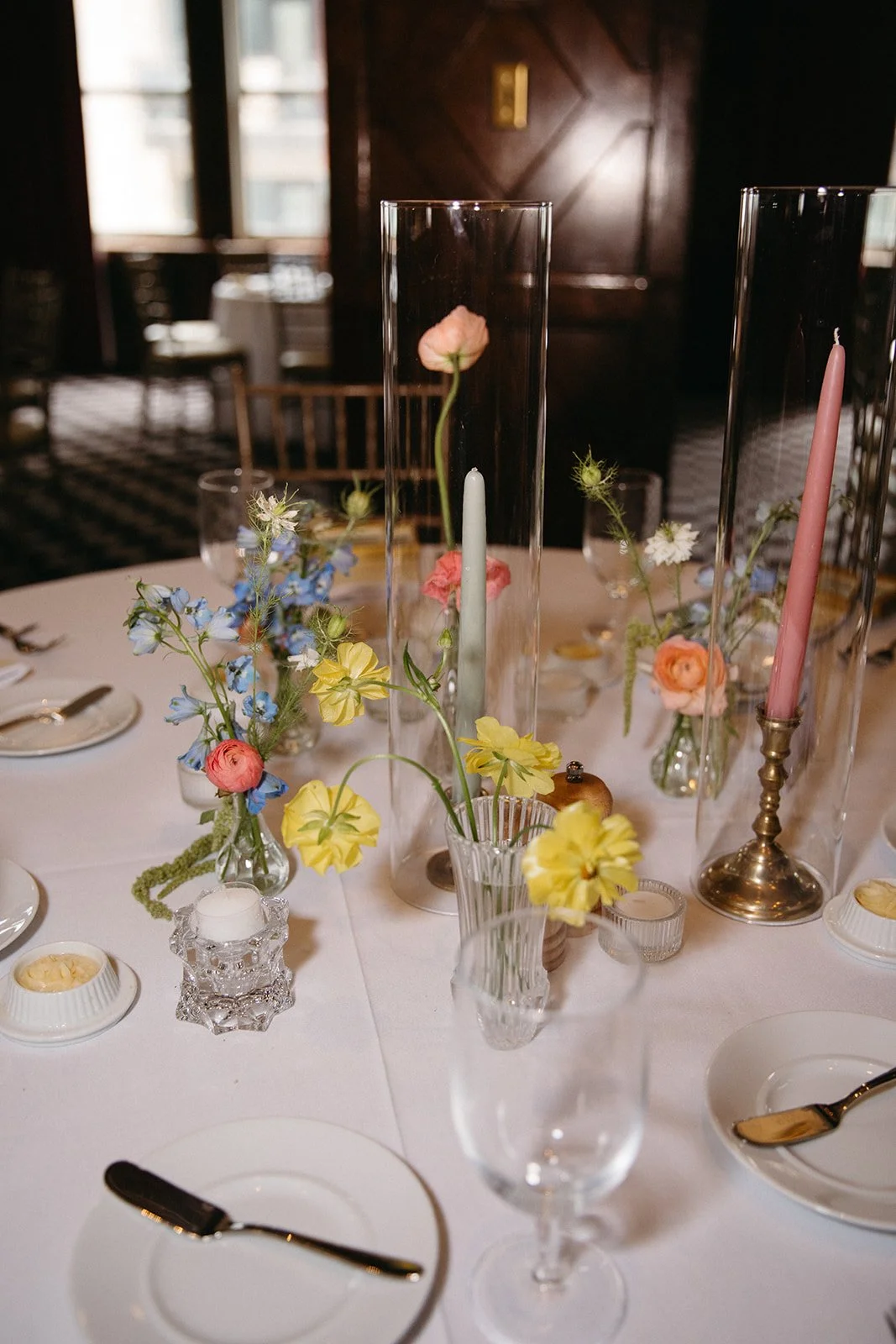 candlelit whimiscal spring garden wedding pastel color palette same sex wedding reception table floral centerpieces downtown kc hotel kansas city the cottage rose kansas city wedding florist crossroads bud vases