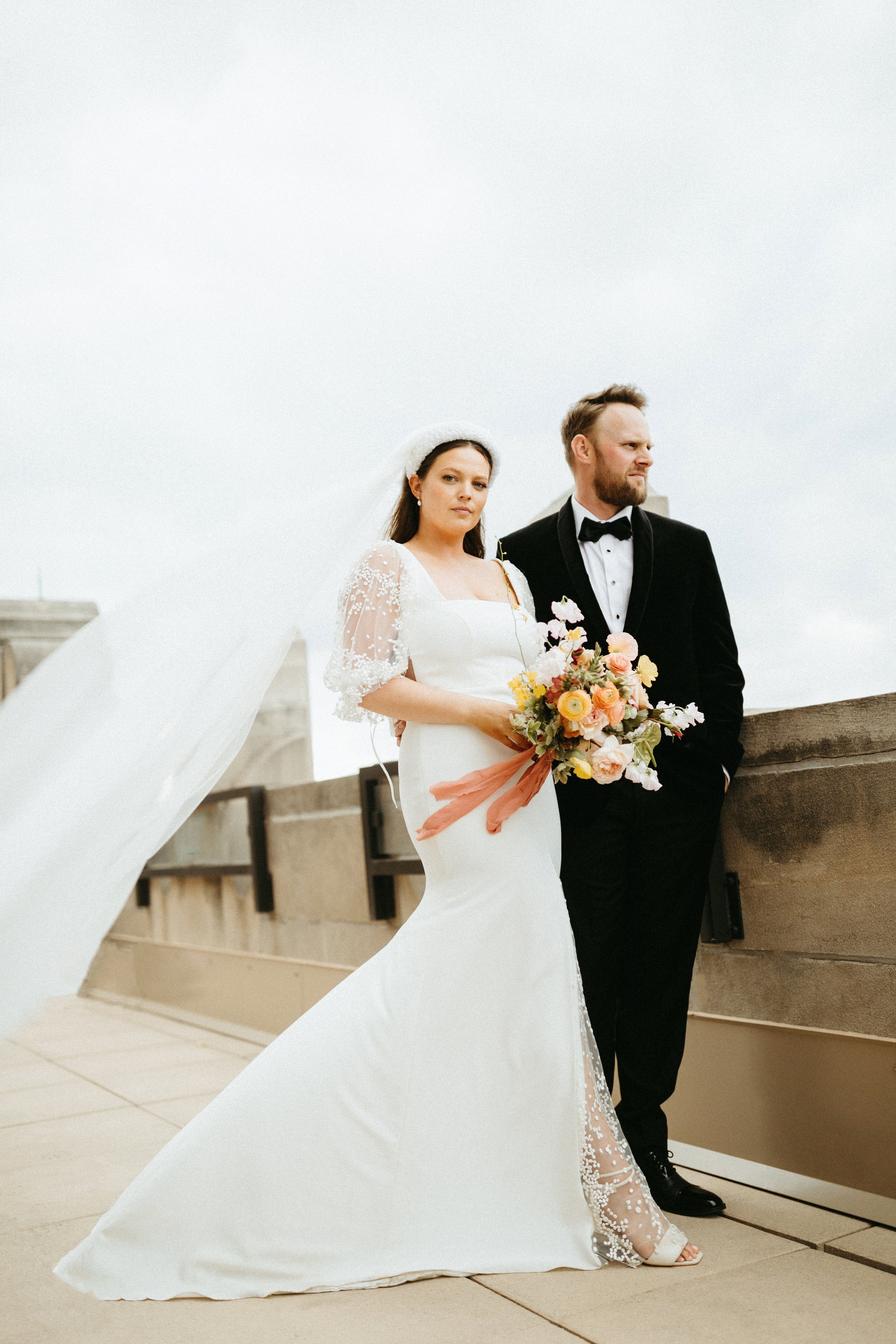Bride and groom portrait rooftop view backdrop large lush spring bridal bouquet modern bridal style the grand hall downtown kc the cottage rose kansas city wedding florist crossroads