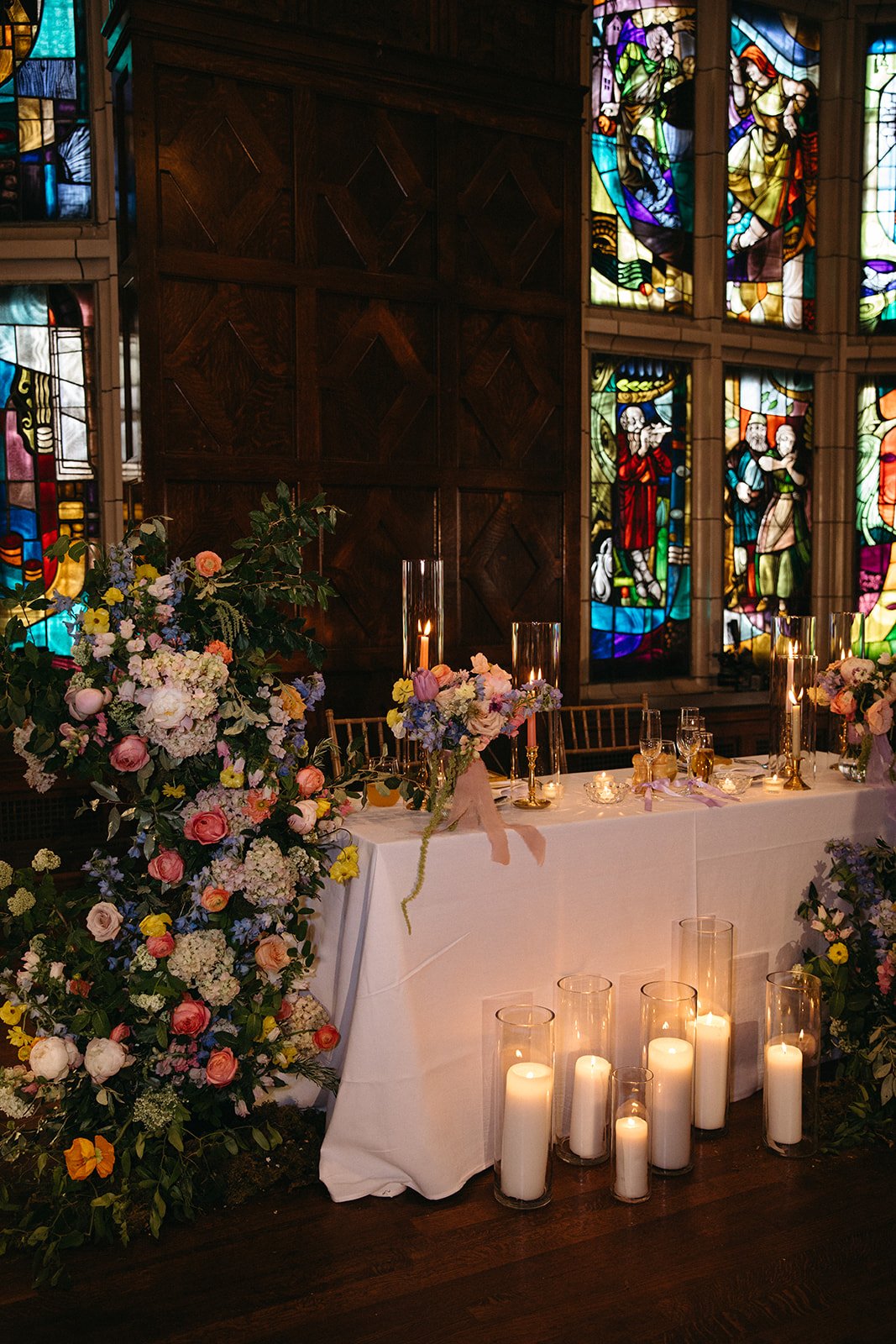 candlelit whimiscal spring garden wedding pastel color palette same sex wedding reception sweetheart table floral installation aisle flowers downtown kc hotel kansas city the cottage rose kansas city wedding florist crossroads