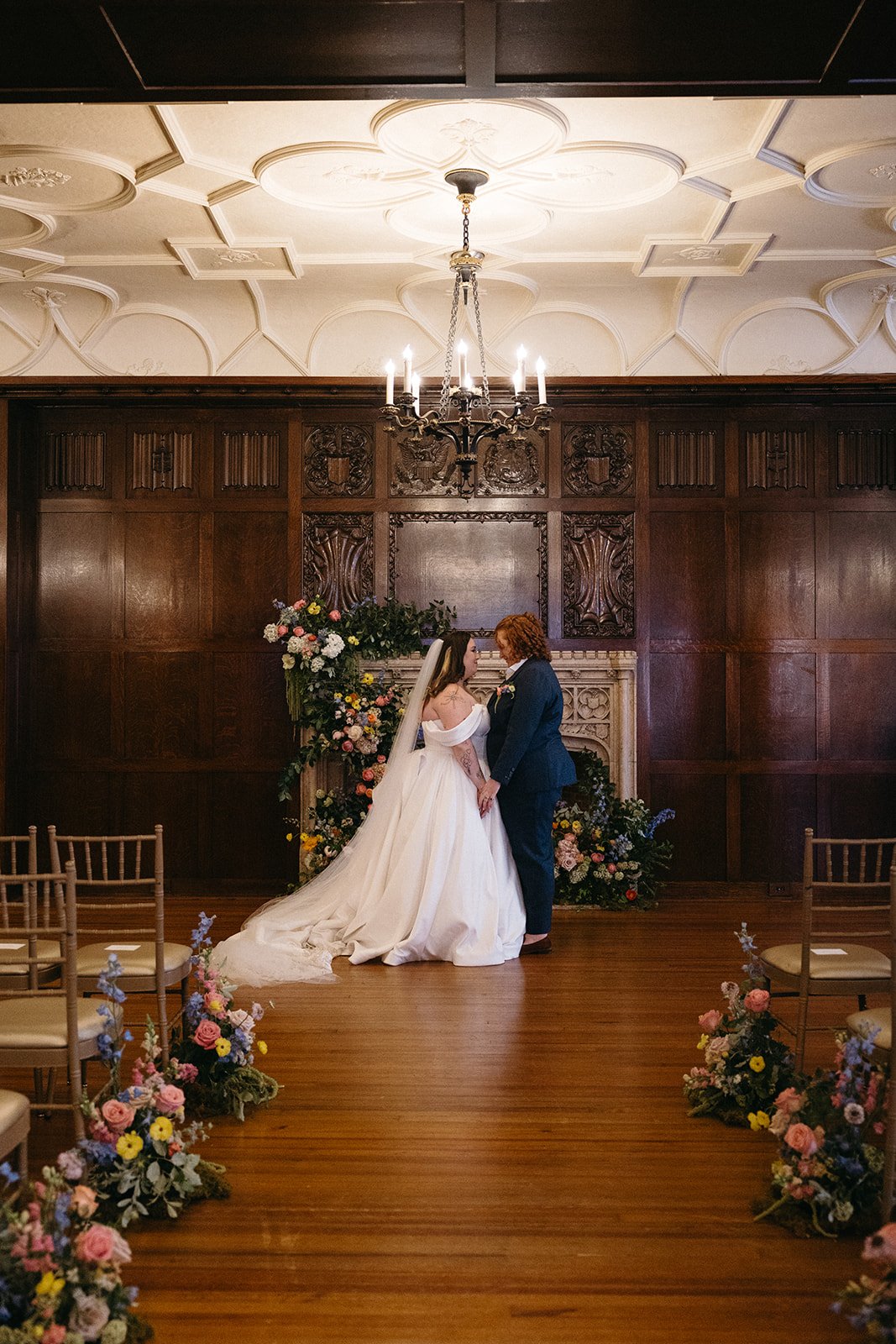 whimiscal spring garden wedding pastel color palette same sex wedding ceremony fireplace floral installation aisle flowers downtown kc hotel kansas city the cottage rose kansas city wedding florist crossroads