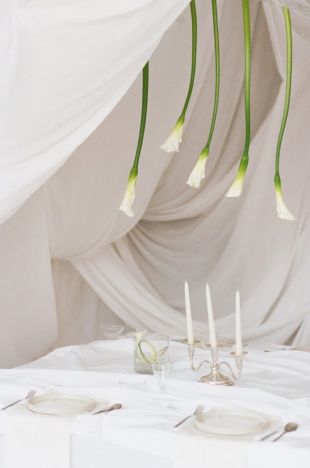 Chic Modern Baby Shower in a Cloud with layers of white draped fabric, simple calla lily centerpieces,  silver candlesticks, hanging floral installation the cottage rose kansas city florist crossroads