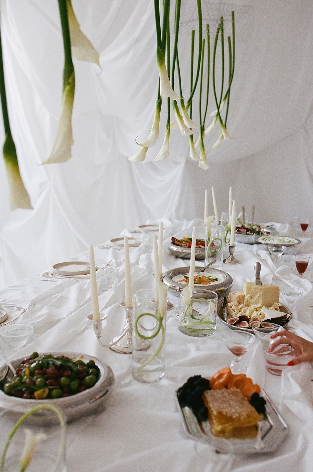 Chic Modern Baby Shower in a Cloud with layers of white draped fabric, simple calla lily centerpieces,  silver candlesticks, hanging floral installation the cottage rose kansas city florist crossroads white set silver food platters