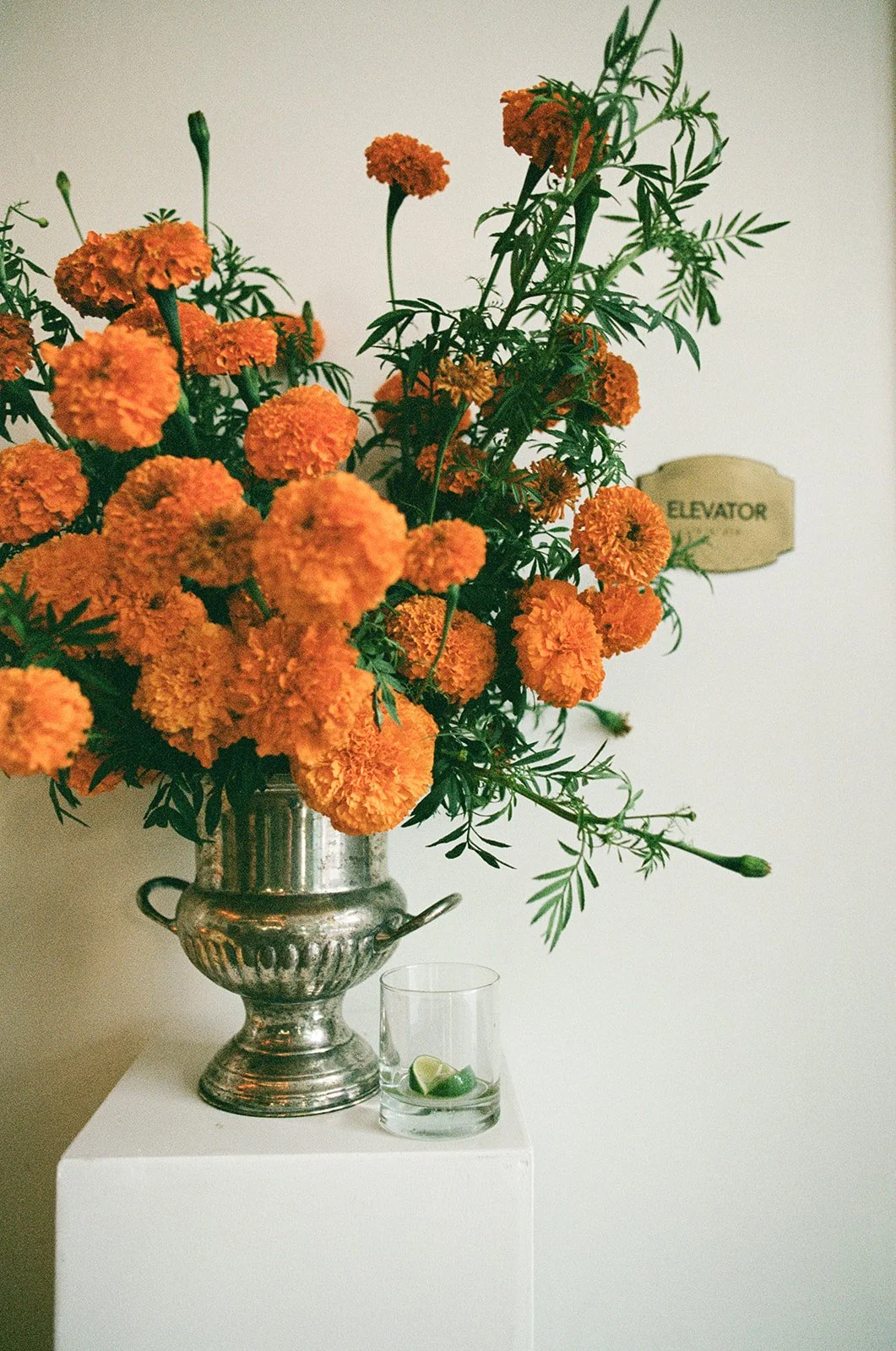 Modern september wedding reception orange and yellow color palette floral pedestals marigolds repurposed ceremony altar arrangements the cottage rose kansas city wedding florist crossroads hotel kansas city wedding