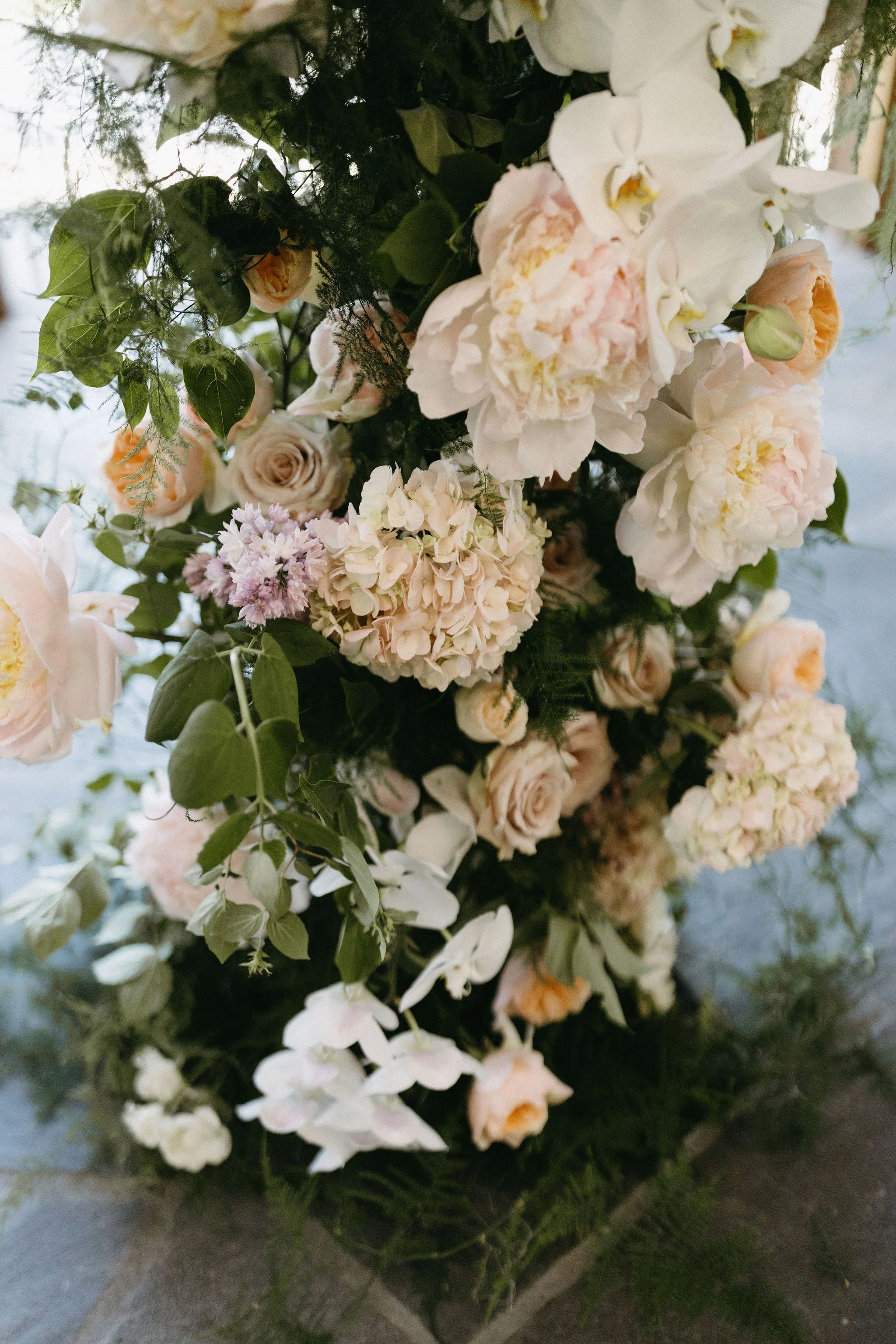 modern spring garden wedding warm color palette yellow peach lilac the cottage rose kansas city florist crossroads powell garden ceremony floral column installation ceremony flower arrangement peonies anthurium garden roses ranunculus orchids