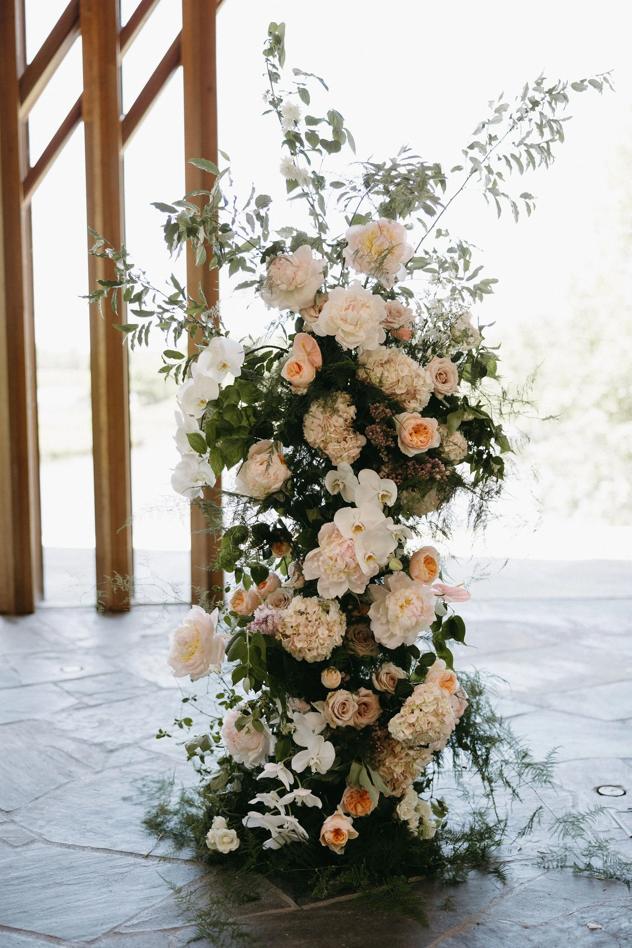 modern spring garden wedding warm color palette yellow peach lilac the cottage rose kansas city florist crossroads powell garden ceremony floral column installation ceremony flower arrangement peonies anthurium garden roses ranunculus orchids