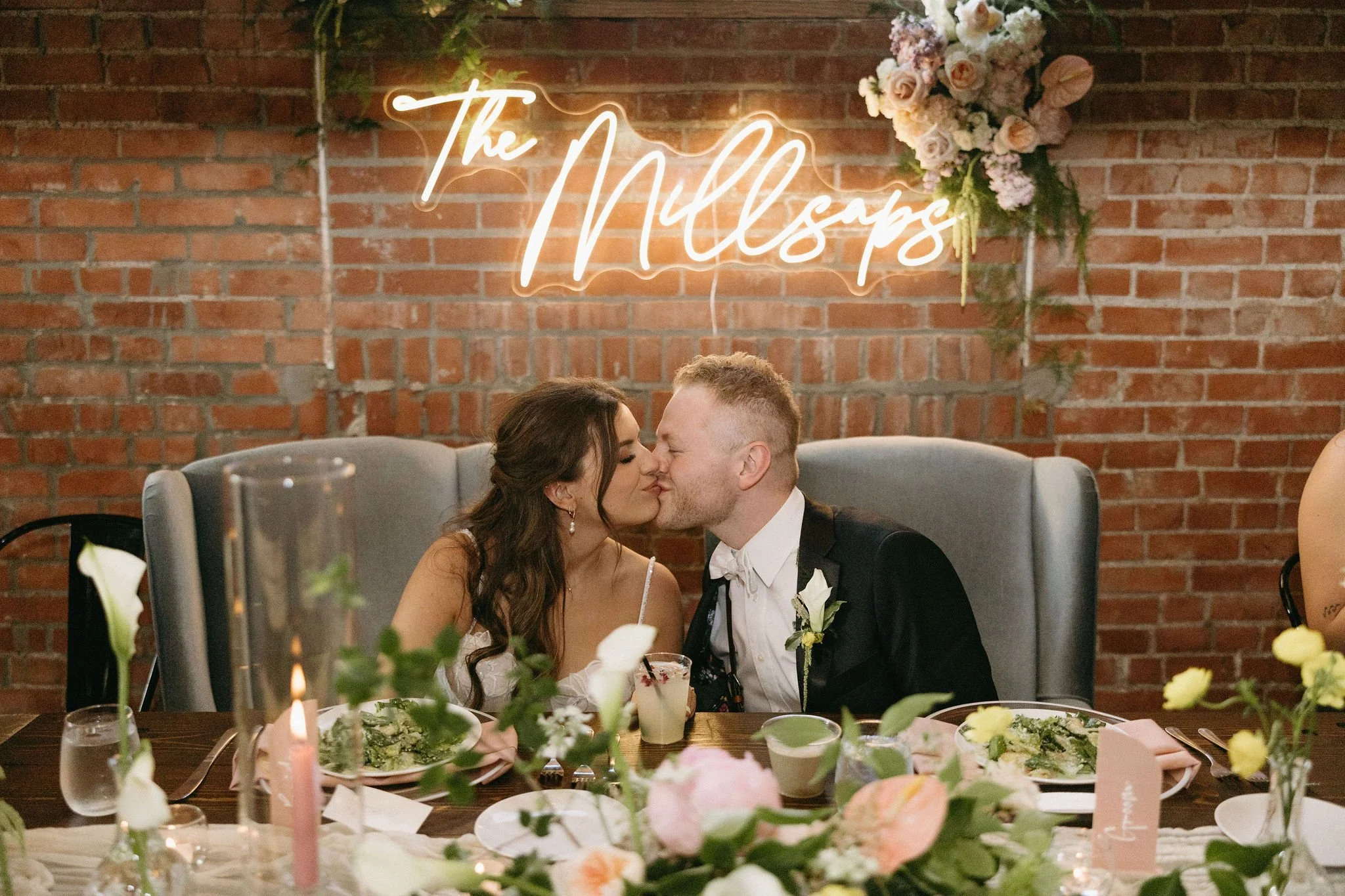 modern spring garden wedding warm color palette yellow peach green the cottage rose kansas city florist crossroads powell garden reception hanging greenery bud vases taper candles ikebana flower arrangements centerpieces head table decor couple neon