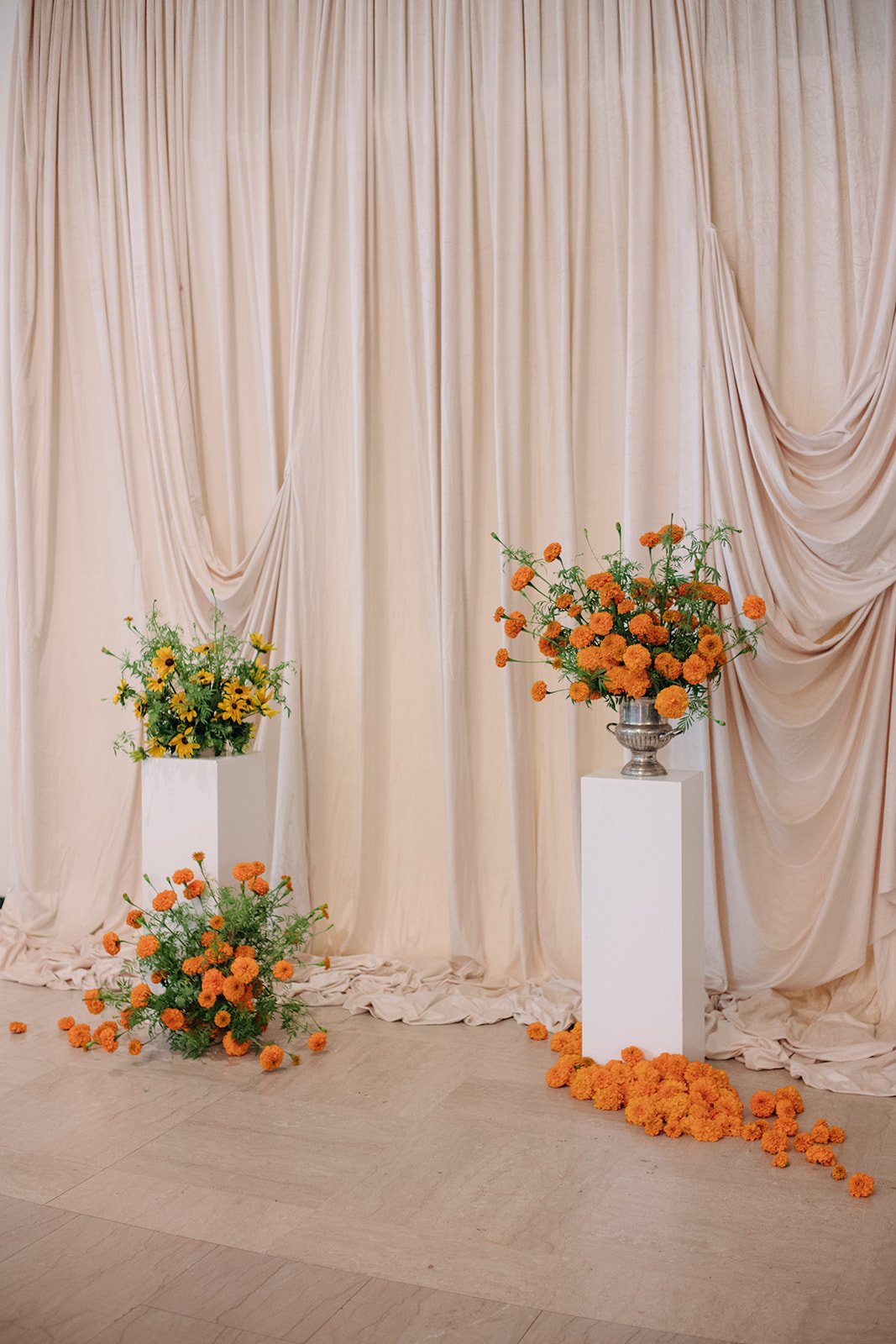 Modern september wedding ceremony ivory draped fabric orange and yellow color palette floral pedestals marigolds library wedding ceremony altar arrangements the cottage rose kansas city wedding florist crossroads hotel kansas city wedding