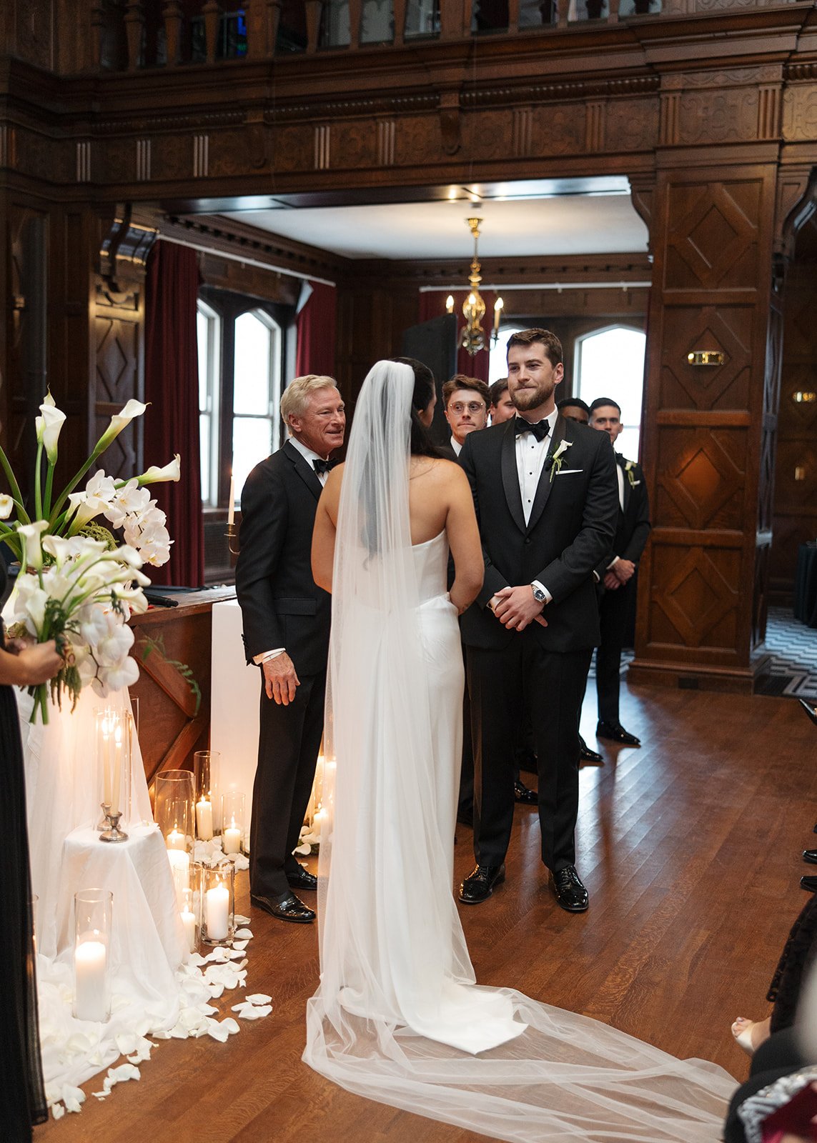 Modern chic november fall wedding downtown hotel kansas city rose petals orchids calla lilies amaranth wedding ceremony arrangement pedestal candles fabric altar installation the cottage rose kansas city wedding florist crossroads