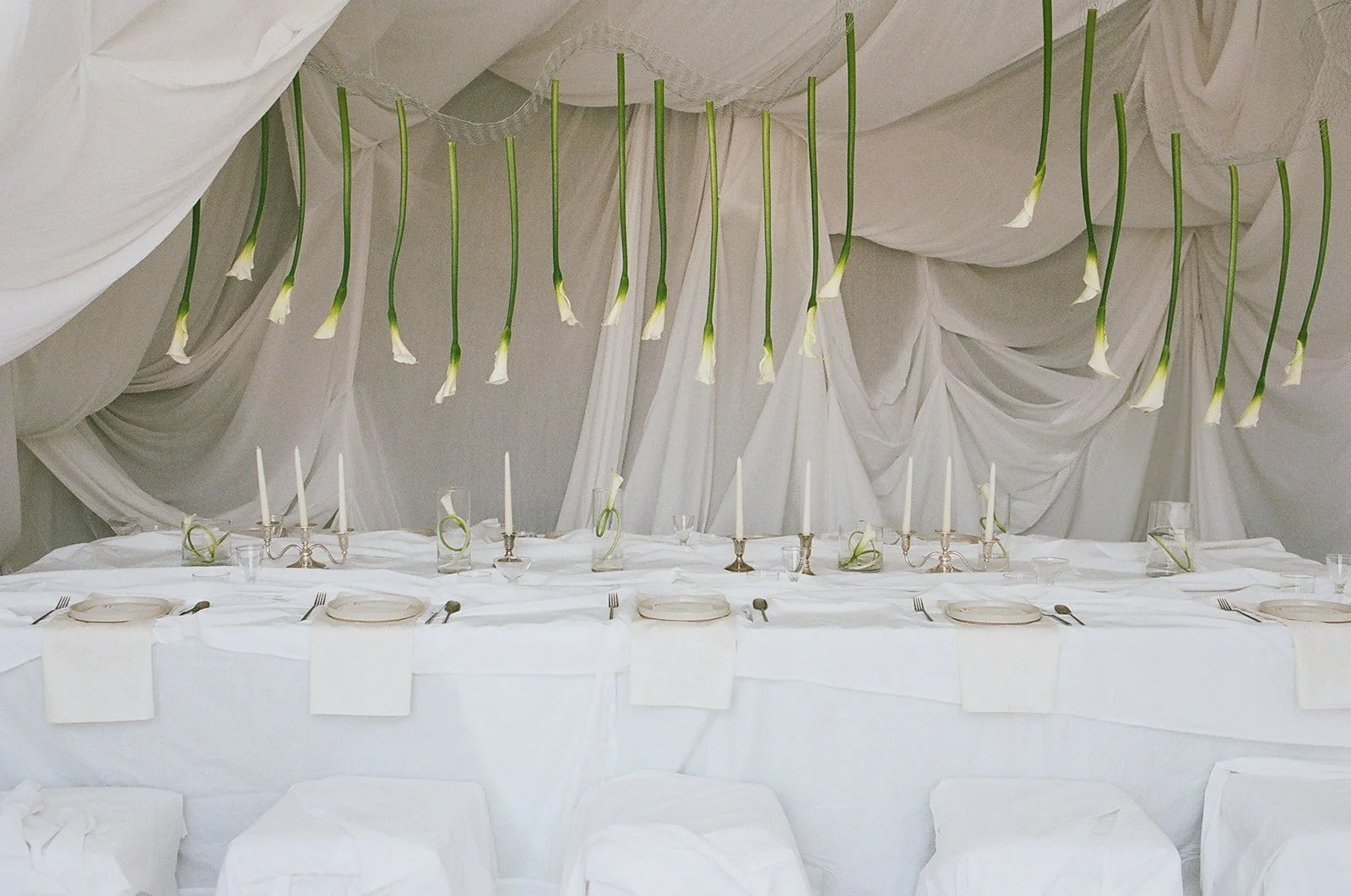 Chic Modern Baby Shower in a Cloud with layers of white draped fabric, simple calla lily centerpieces,  silver candlesticks, hanging floral installation the cottage rose kansas city florist crossroads