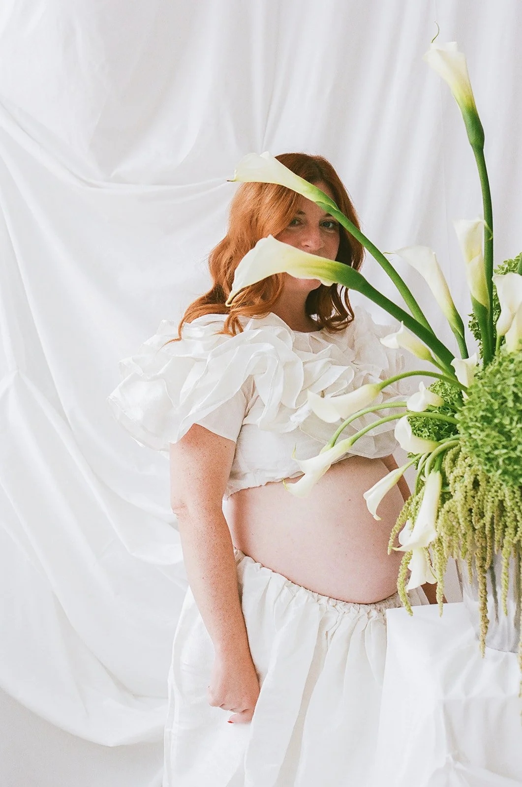 Chic Modern Baby Shower in a Cloud with layers of white draped fabric, simple calla lily centerpieces,  silver candlesticks, hanging floral installation the cottage rose kansas city florist crossroads green hydrangea green amaranth