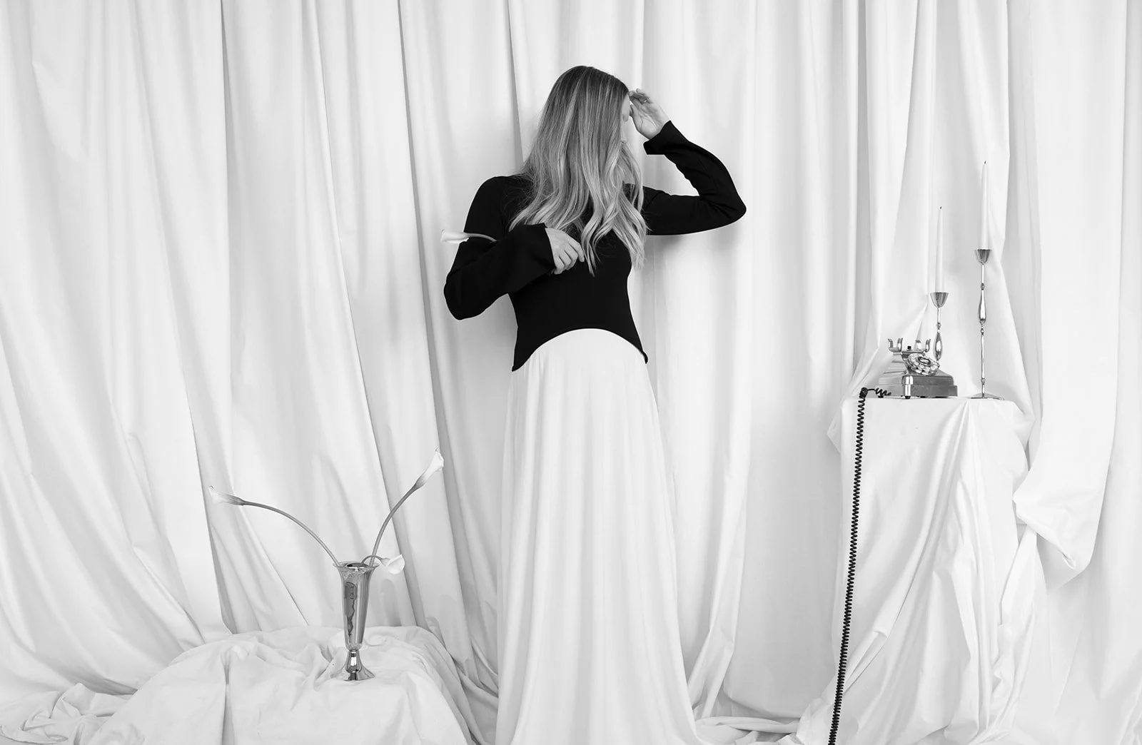 Modern chic branding shoot for an interior designer white calla lilies in silver bud vases the cottage rose kansas city wedding florist crossroads pedestal floral installation draped fabric model in black and white dress