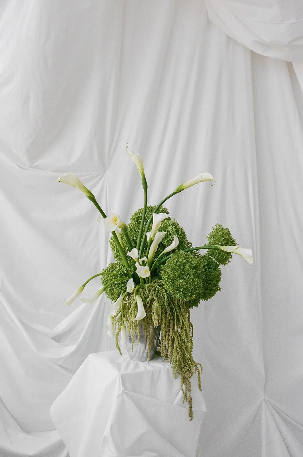Chic Modern Baby Shower in a Cloud with layers of white draped fabric, simple calla lily centerpieces,  silver candlesticks, hanging floral installation the cottage rose kansas city florist crossroads green hydrangea green amaranth