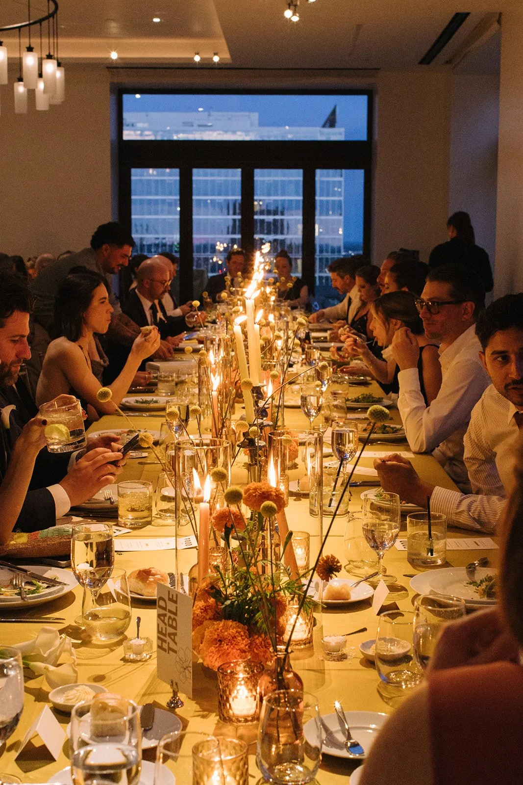 Modern september wedding reception orange and yellow color palette craspedia bud vases centerpieces silver candelabra  the cottage rose kansas city wedding florist crossroads hotel kansas city wedding orange marigold ikebana head table candles