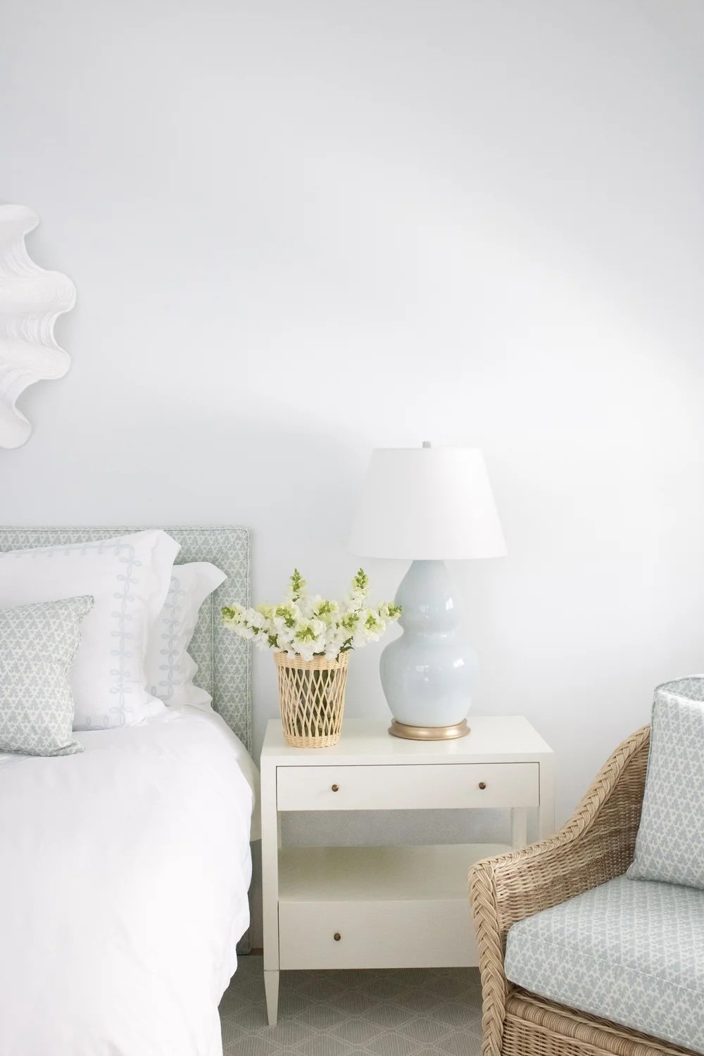 New England luxury spa-like bedroom in soft blue and white with custom headboard