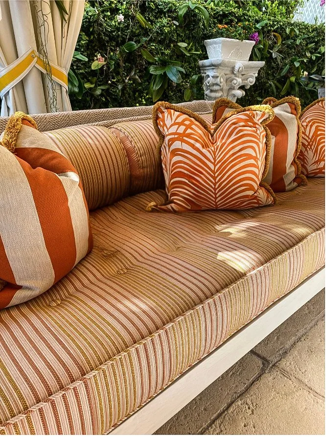 New England luxury outdoor terrace with orange striped sofa and custom zebra pillows