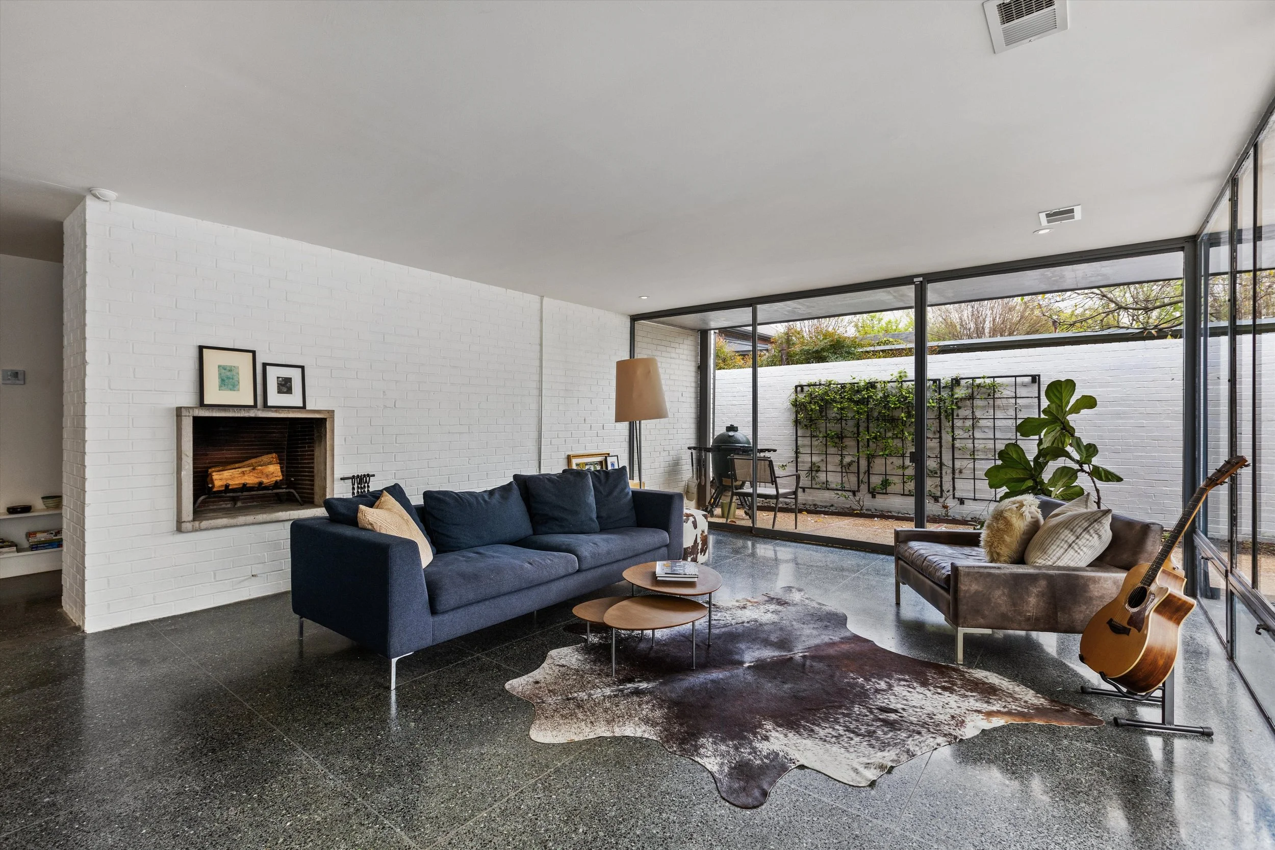 Den with fireplace and terrazzo floors
