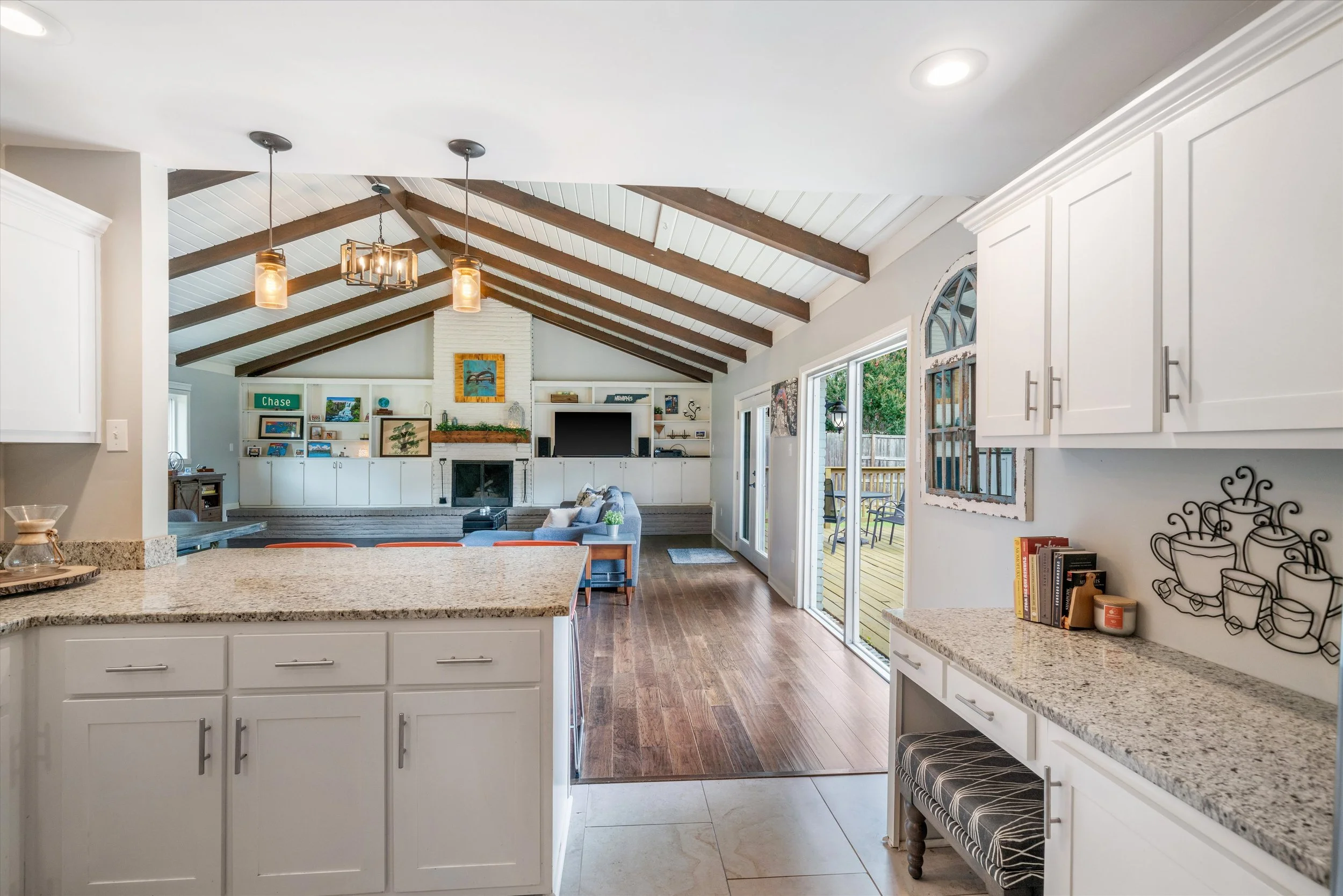 Photo of a kitchen open to avaluted living rom with a fireplace and built-ins
