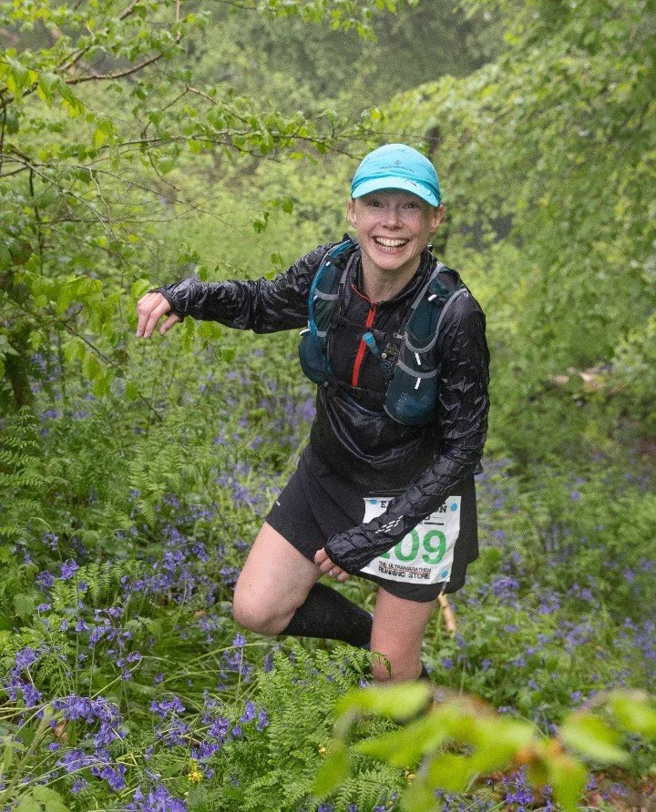 Katharine tackling a wooded hill on a long trail running race
