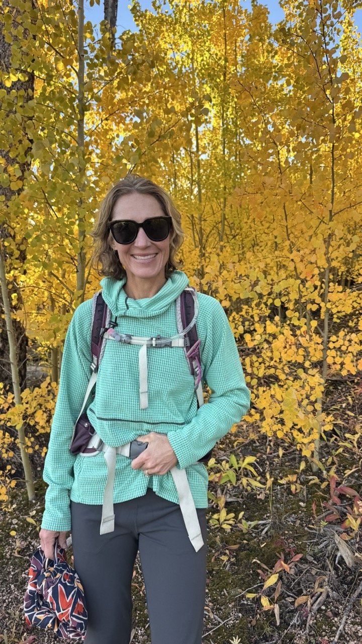 woman hiking in fall in colorado with aspen trees