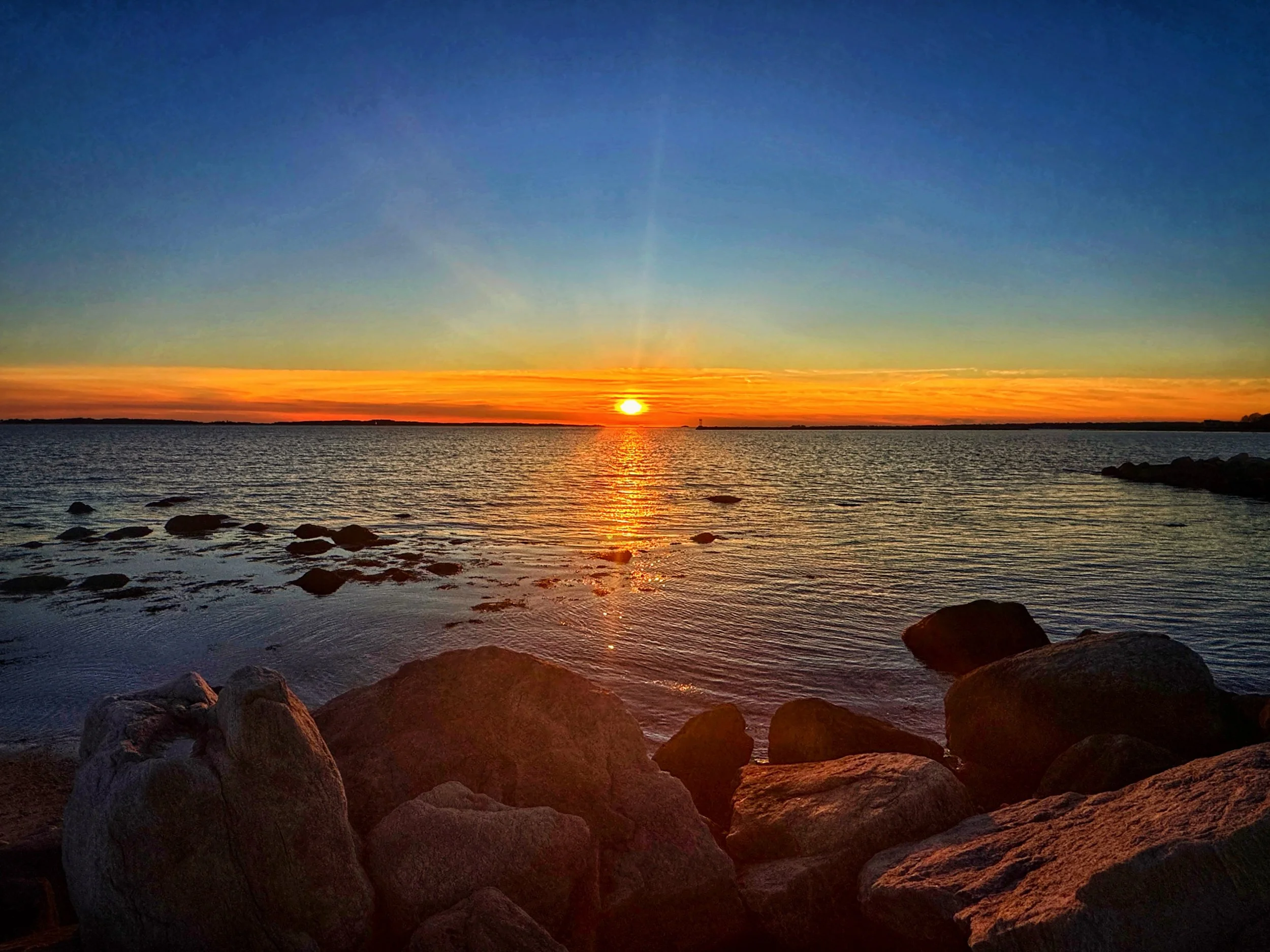 A warm winter sunset as seen from the rocky shore at Stonington Point, Connecticut