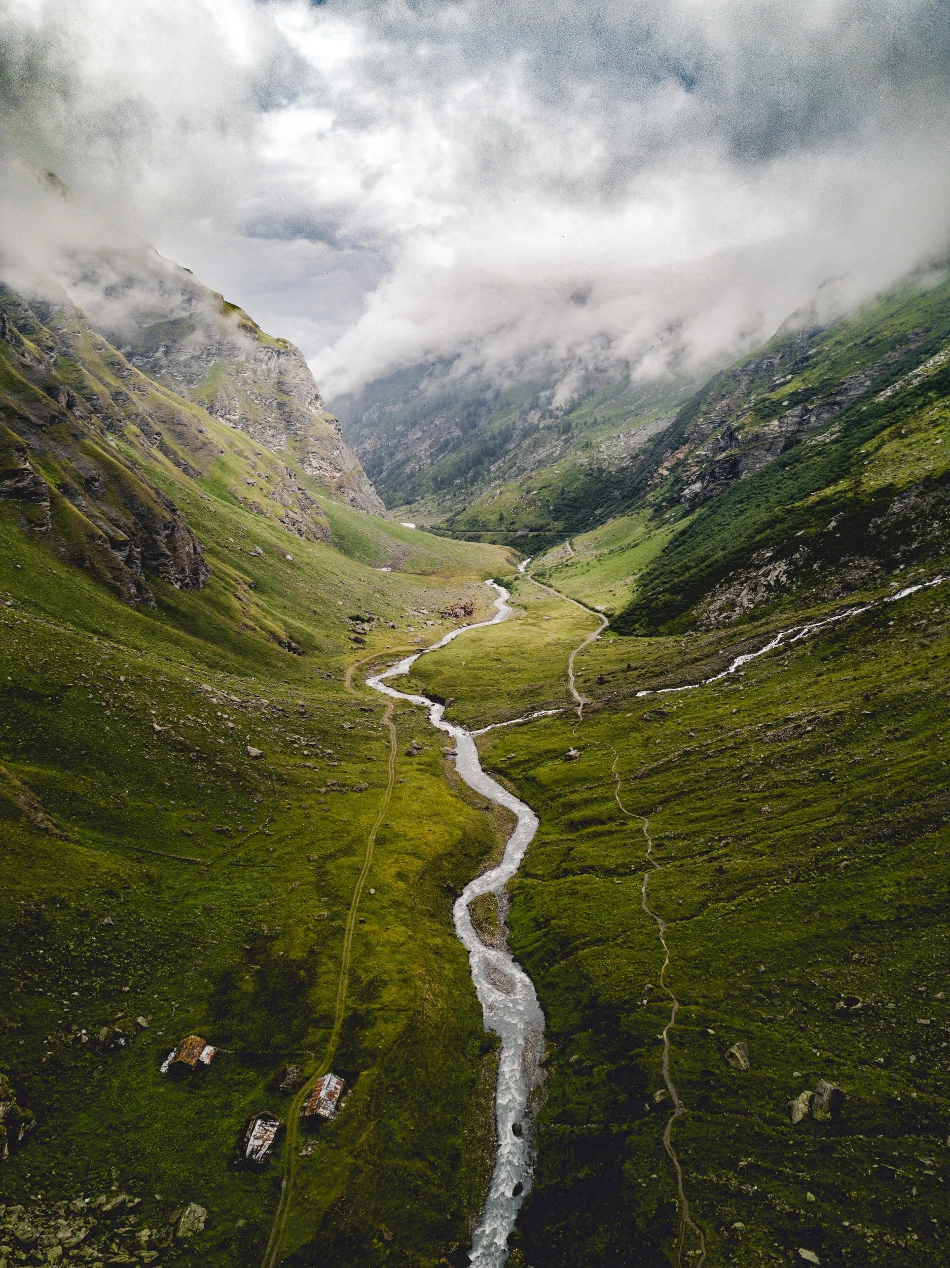A lush mountain valley with a thin stream flowing through the center, representing setting intentions for an ayahuasca retreat ceremony.