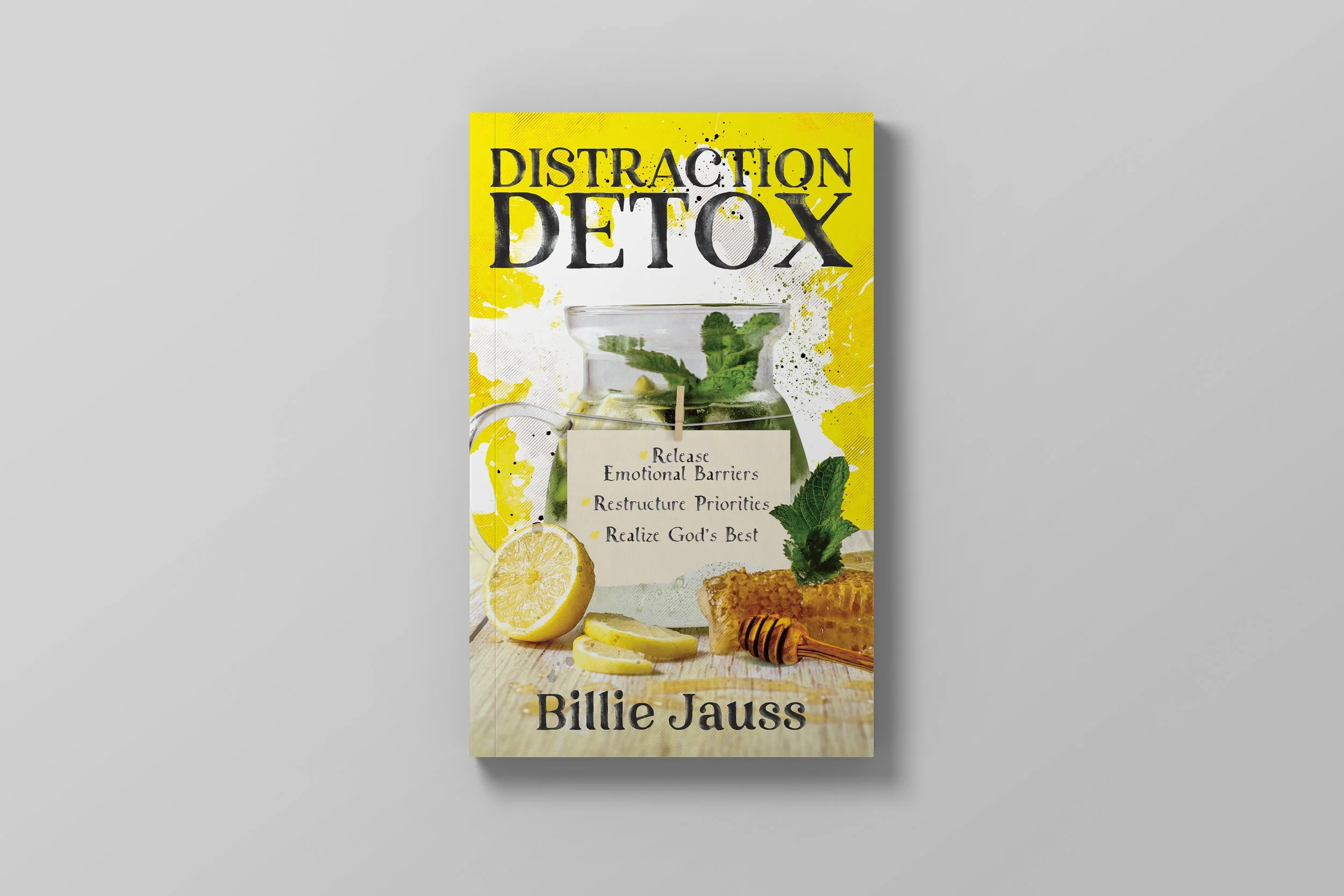 Book cover titled "Distraction Detox" by Billie Jass. The cover features a glass jar filled with lemon slices and mint leaves, a lemon half, lemon slices, honey comb with a honey dipper, and a note with healing messages. The background is yellow with
