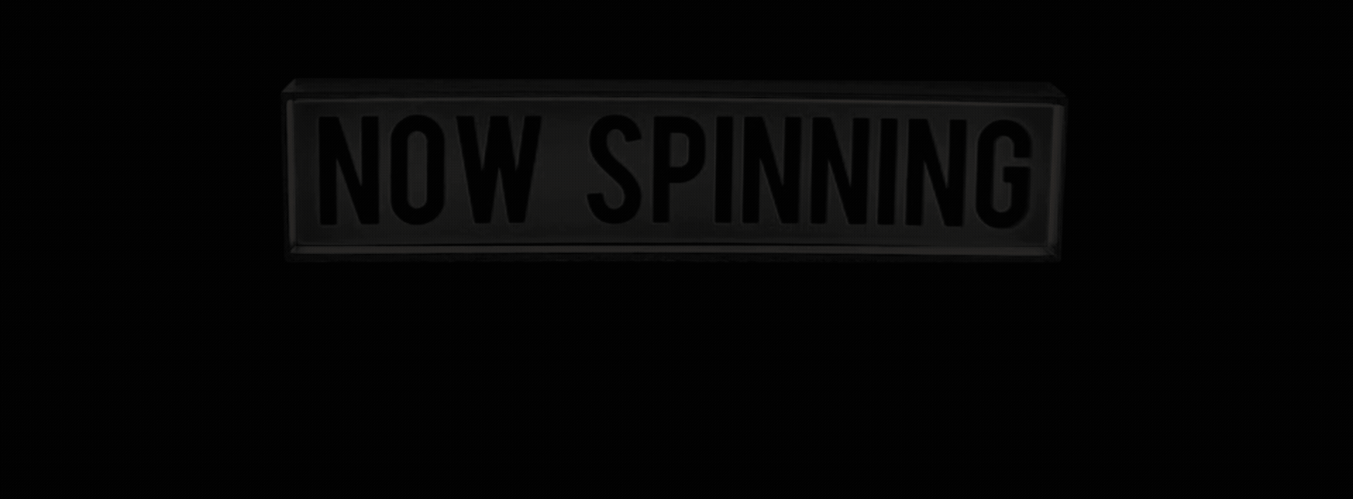 Animated vintage light box sign blinking the words Now Spinning on and off.