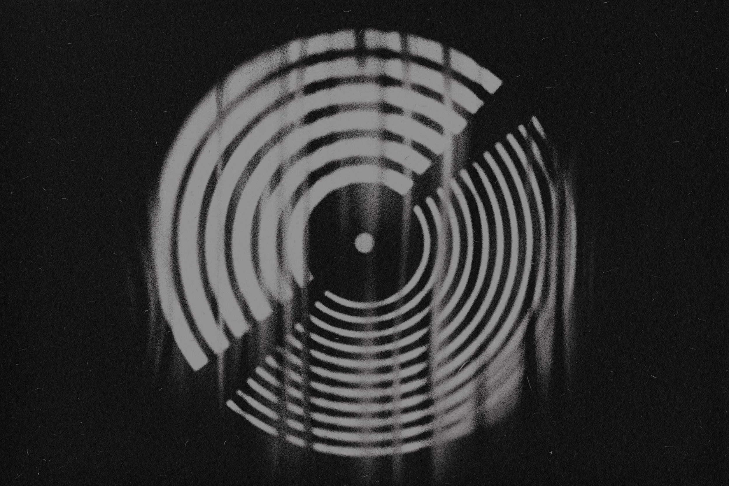 Close-up image of a black and white DISCOGS LOGO  on a dark background.