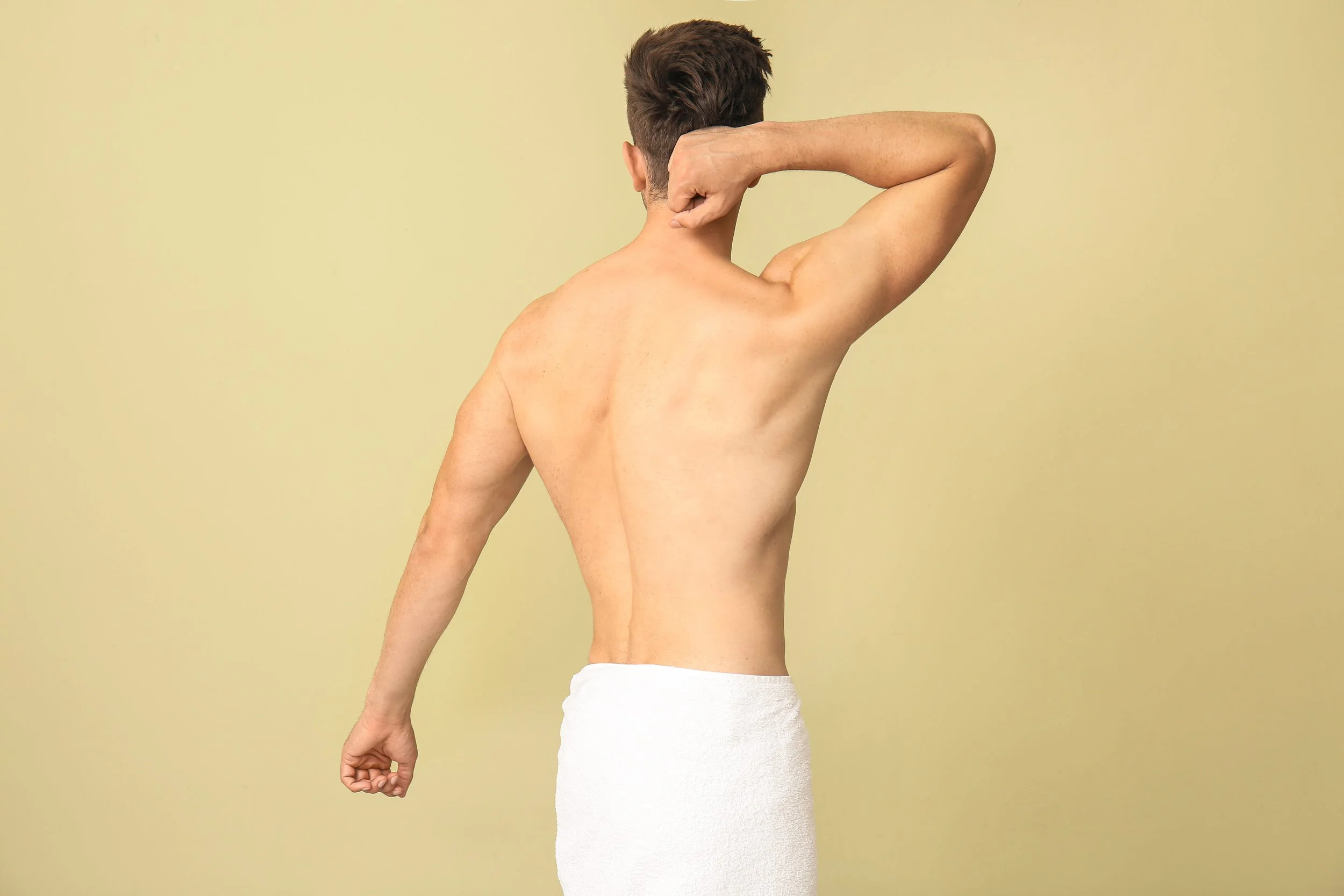 Handsome young man after depilation on color background