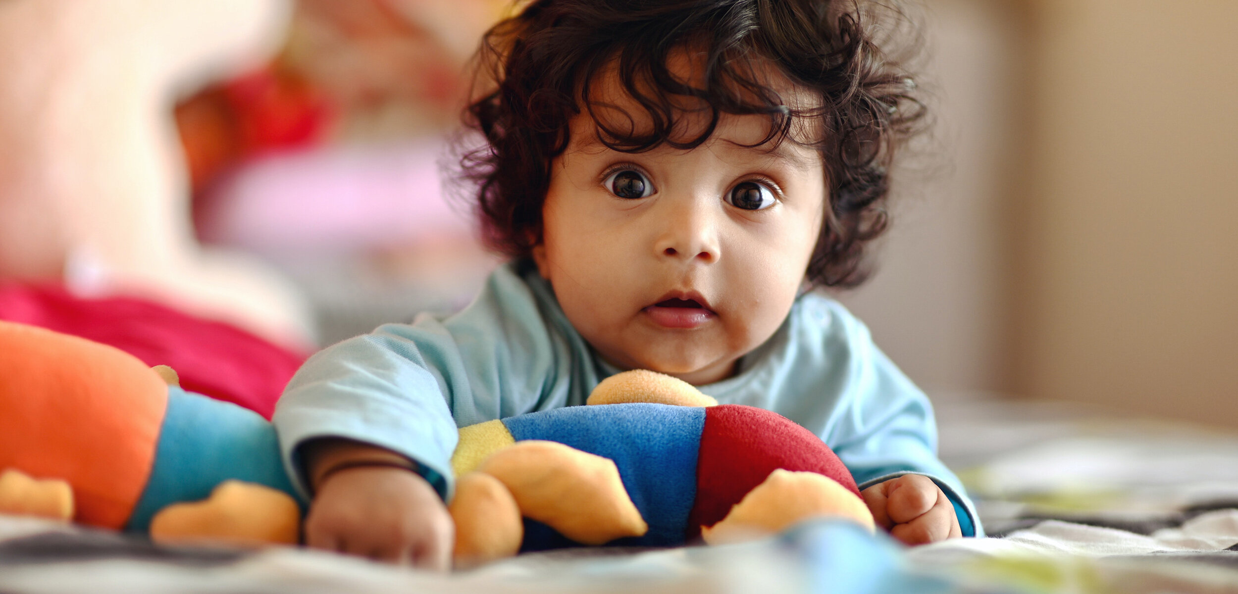 Beautiful baby with big eyes holding soft toy