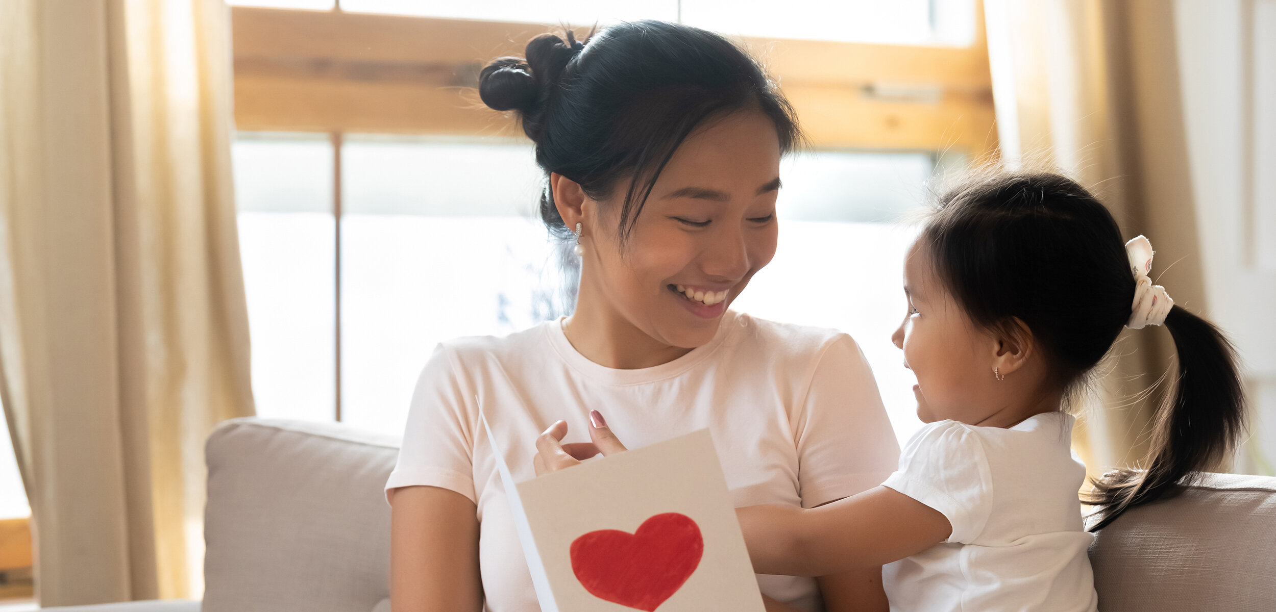 Bangkok Nanny and little girl holding card with red heart